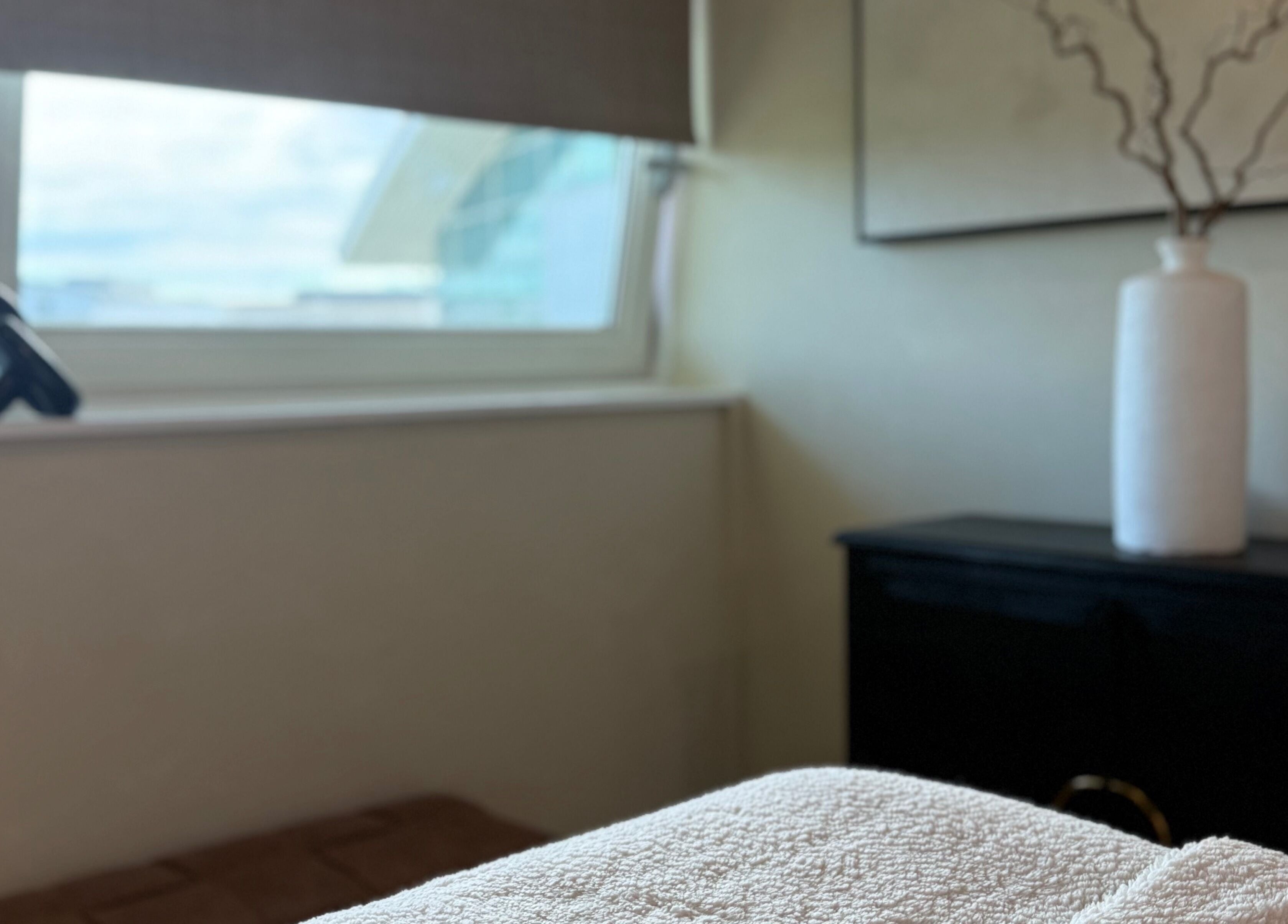 Relaxing room at The Glow Clinic, Cardiff Bay, GB with soft lighting and calm decor.