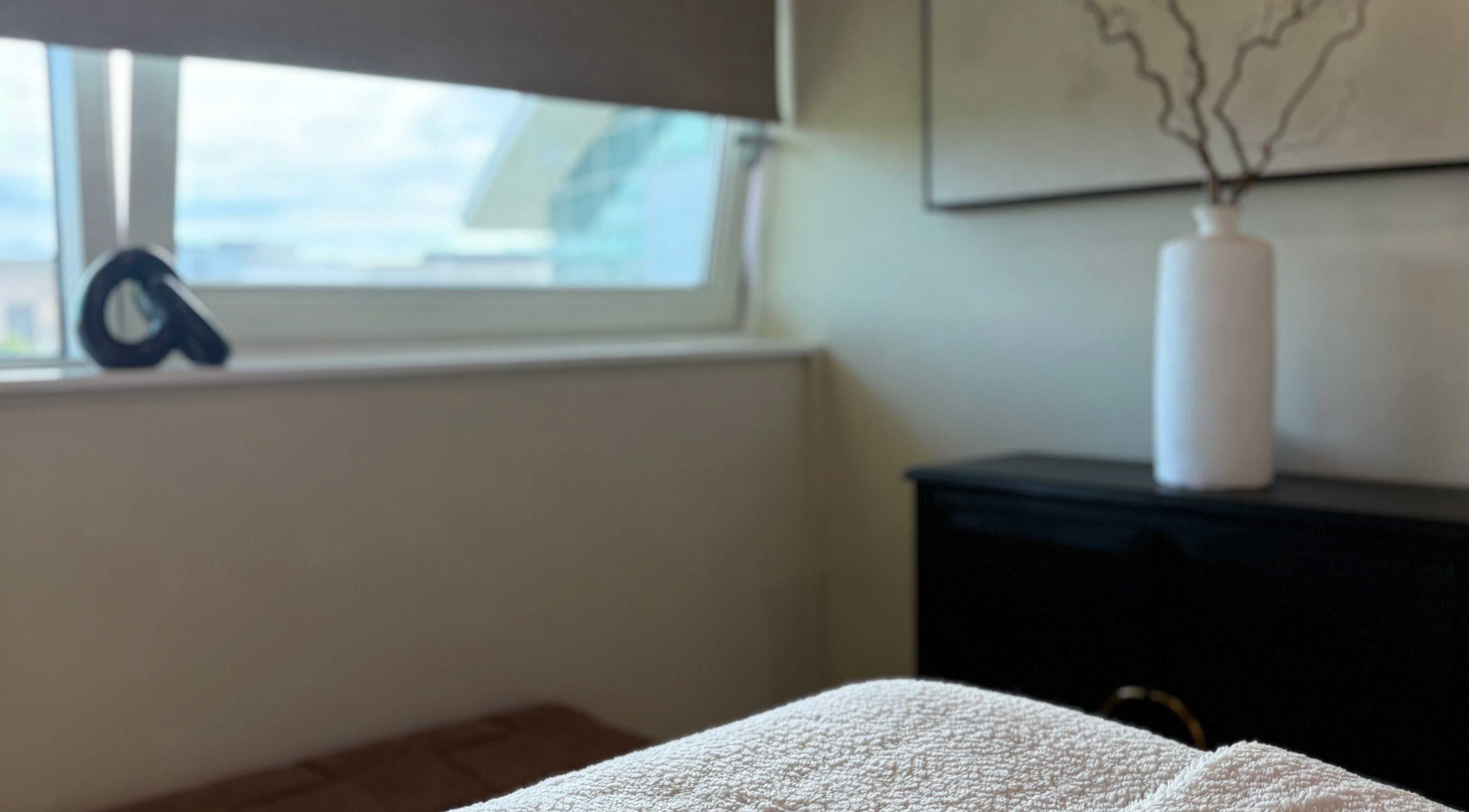 Relaxing room at The Glow Clinic, Cardiff Bay, GB with soft lighting and calm decor.