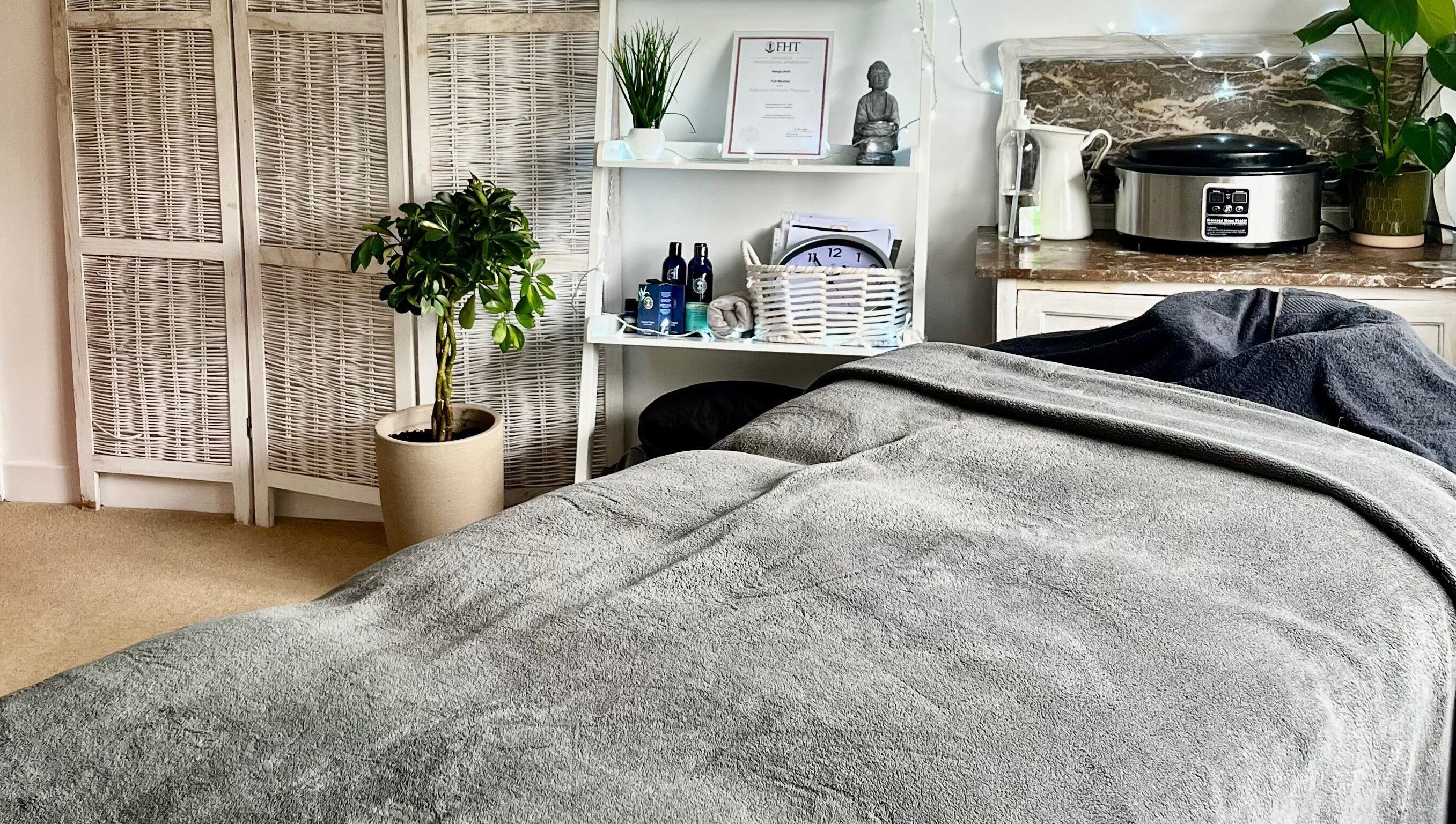 A serene therapy room at Gower Garden Therapies, Southgate, Wales, GB with a cozy massage table and calming decor.