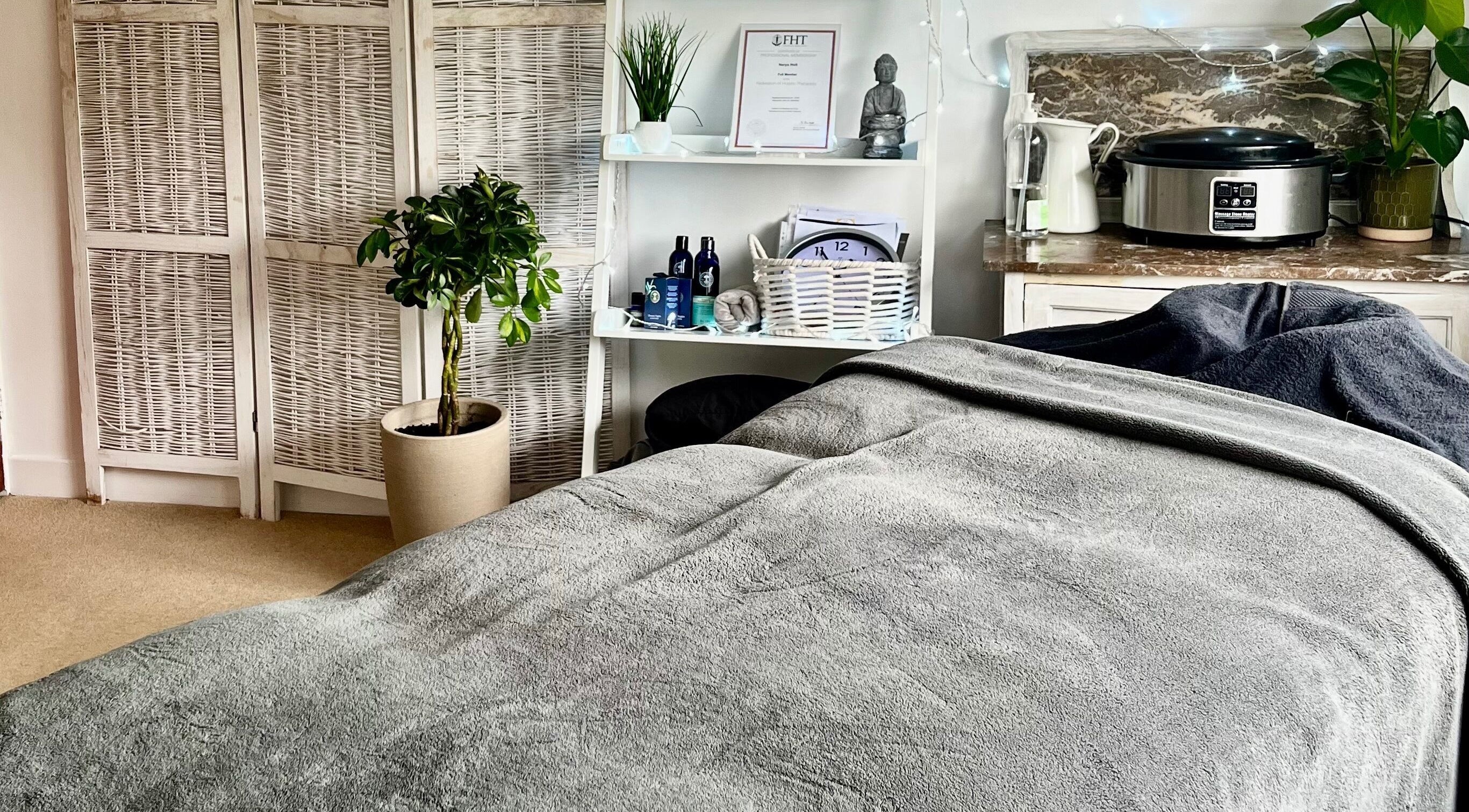 A serene therapy room at Gower Garden Therapies, Southgate, Wales, GB with a cozy massage table and calming decor.