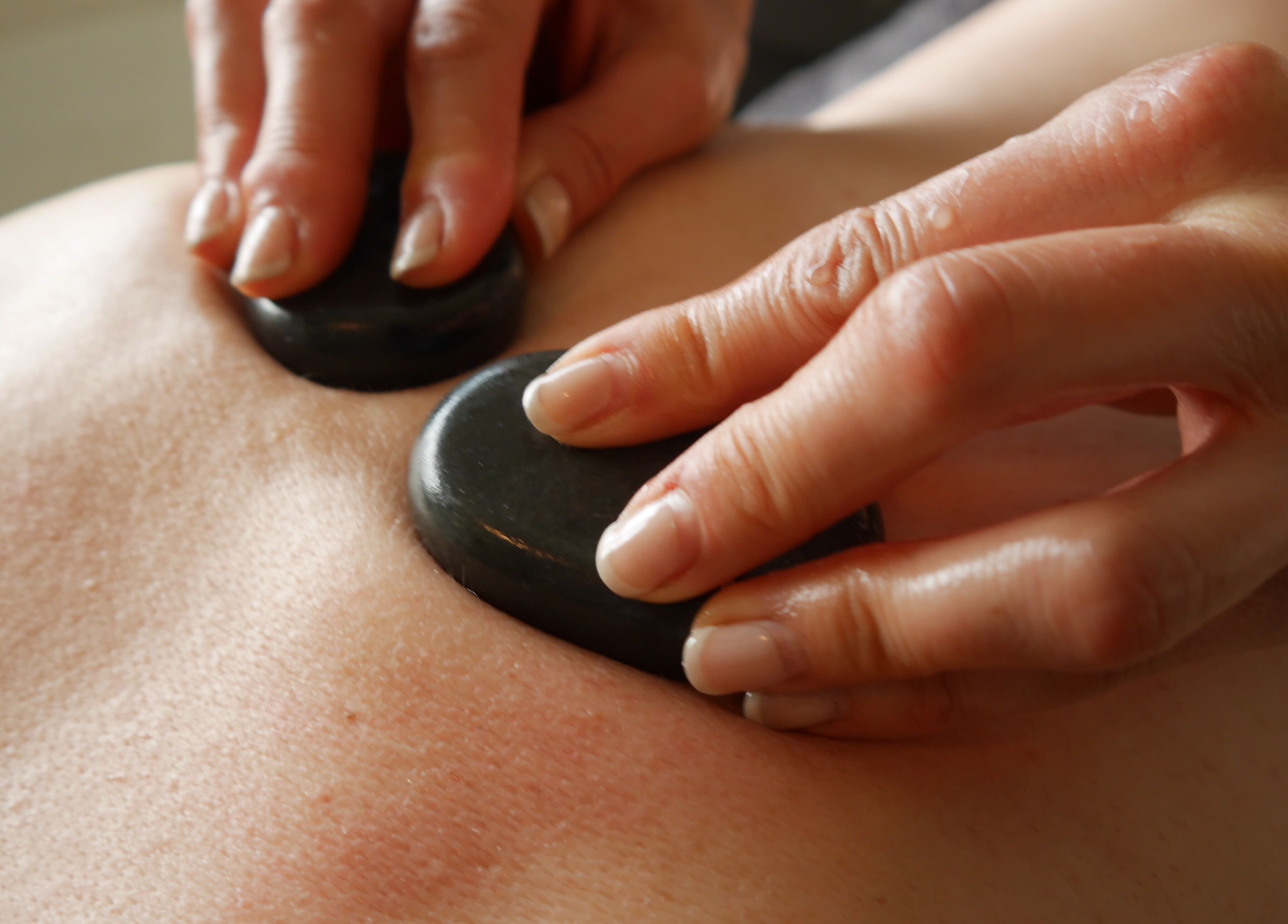 Relaxing hot stone therapy at Gower Garden Therapies, Southgate, Wales, GB. Luxurious wellness experience.
