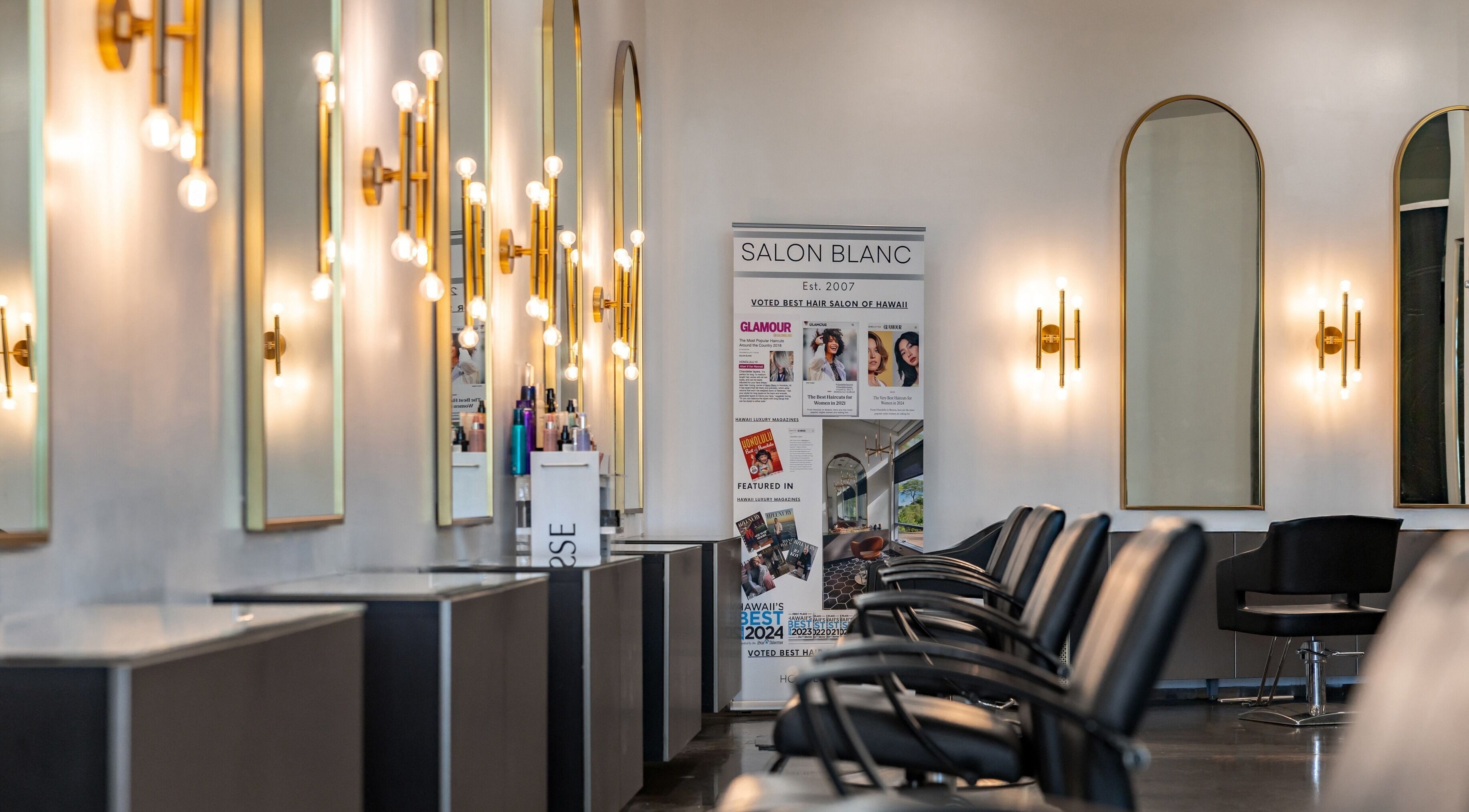 Elegant interior of Salon Blanc the celebrities salon in Honolulu, Hawaii, US featuring stylish mirrors and seating.