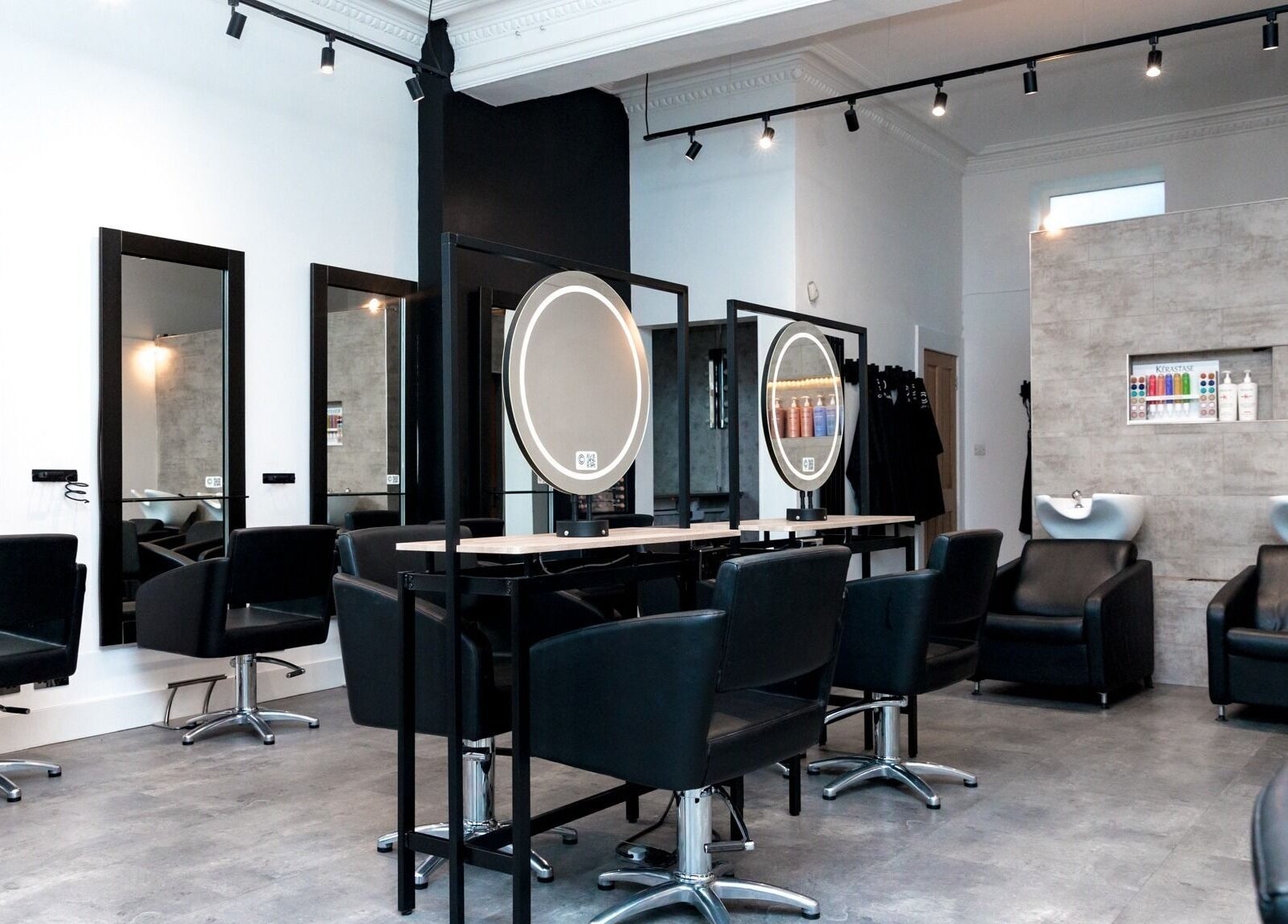 Chic and modern interior of Cascal Hair Studio in Edinburgh, Scotland, GB. Stylish black chairs and mirrors.
