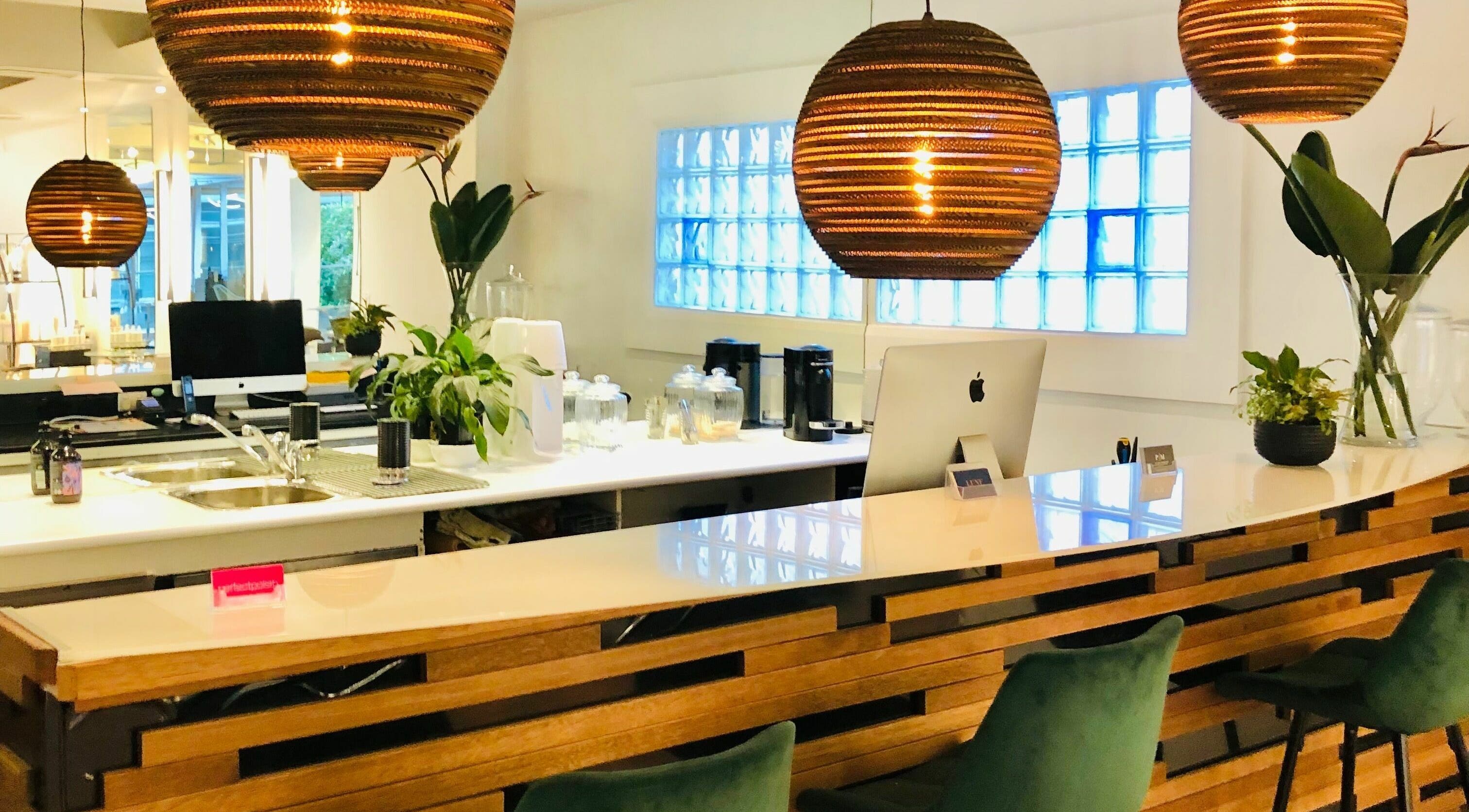 Stylish reception area at Prodigal Hairdressing, Toorak, Victoria, AU with modern decor and warm lighting.