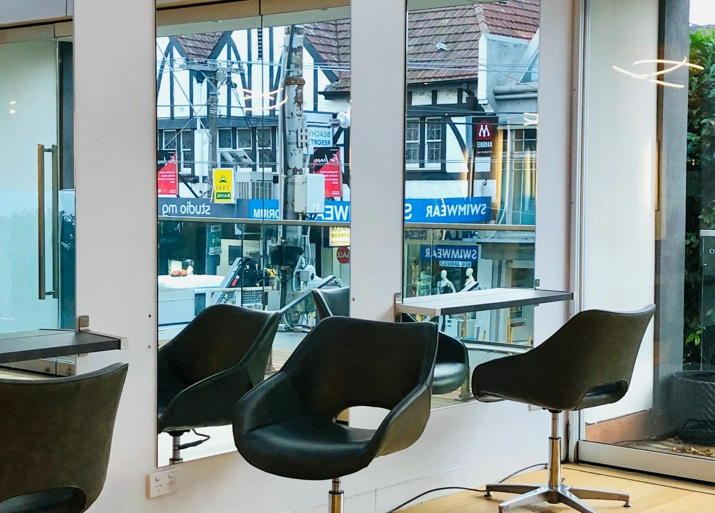 Modern interior of Prodigal Hairdressing in Toorak, Victoria, AU, featuring stylish chairs and large mirrors.