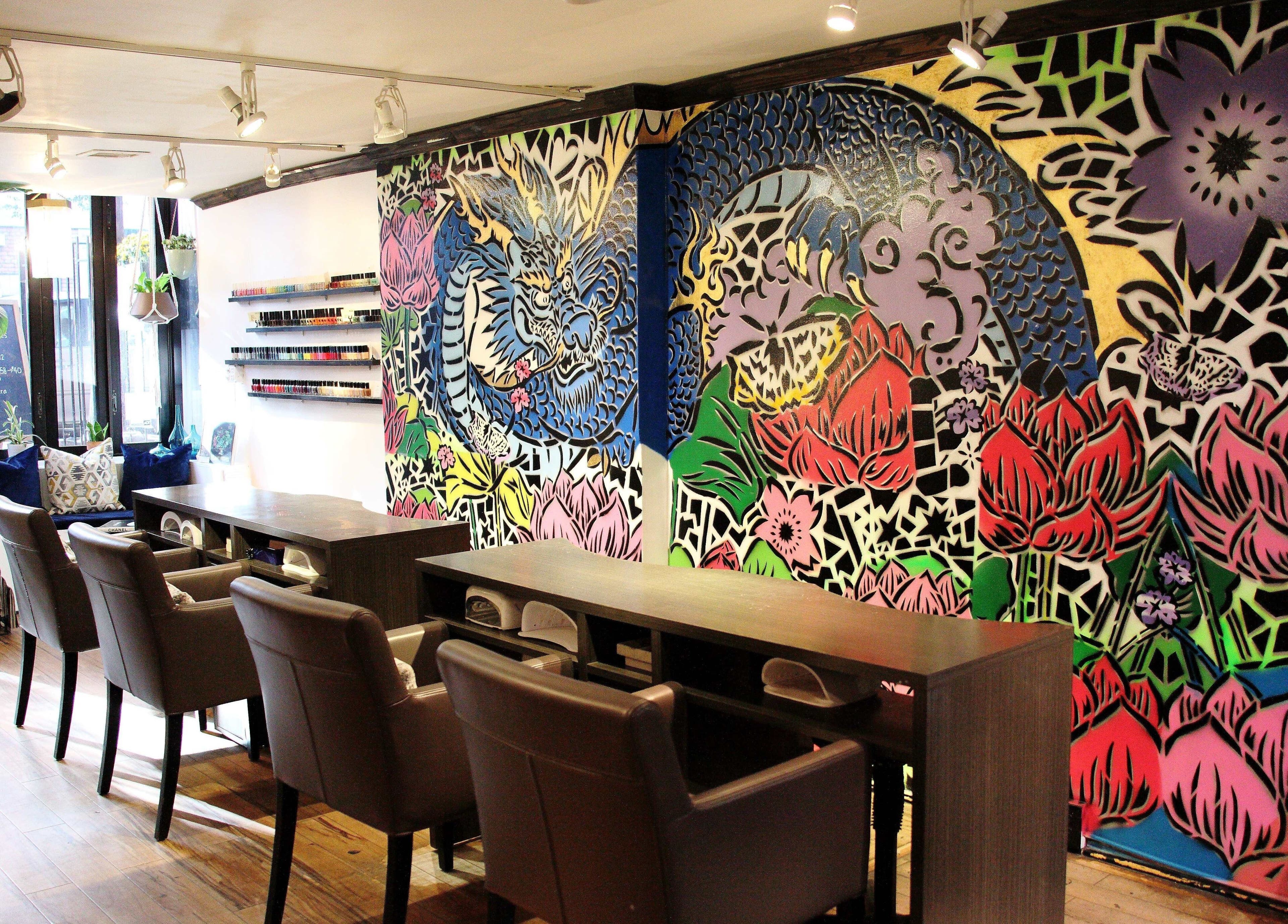 Vibrant, artistic interior of VIBLiSSiMO Art of Beauty in New York, US with colorful wall murals and manicure stations.