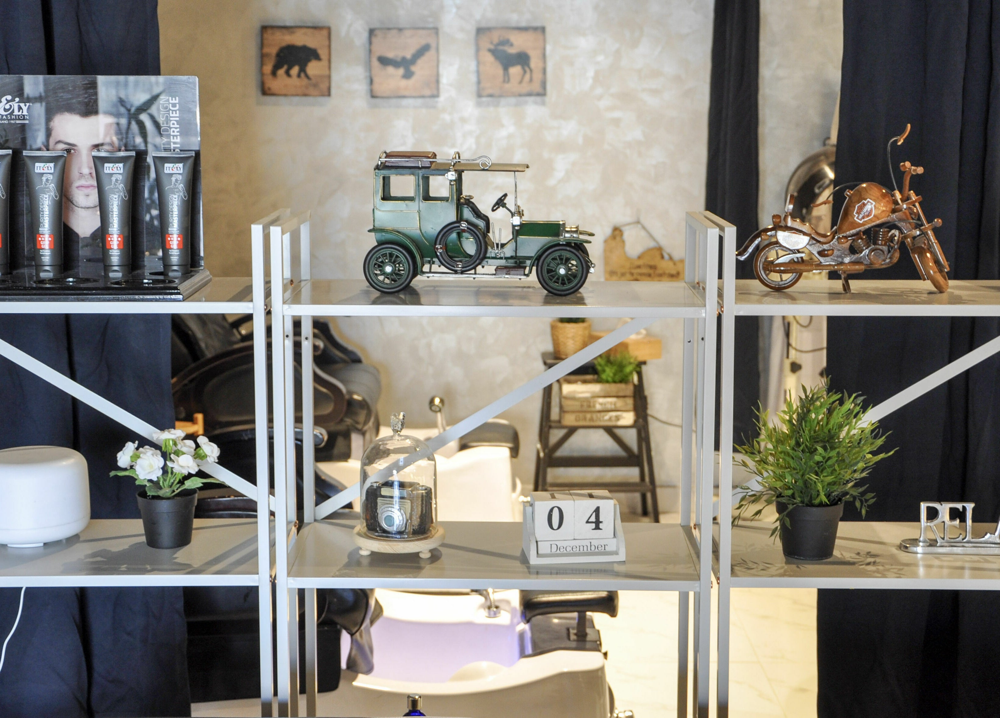 Stylish decor at The Loft Prime Gent's Salon, Dubai, Dubai, AE with vintage car model and grooming products.