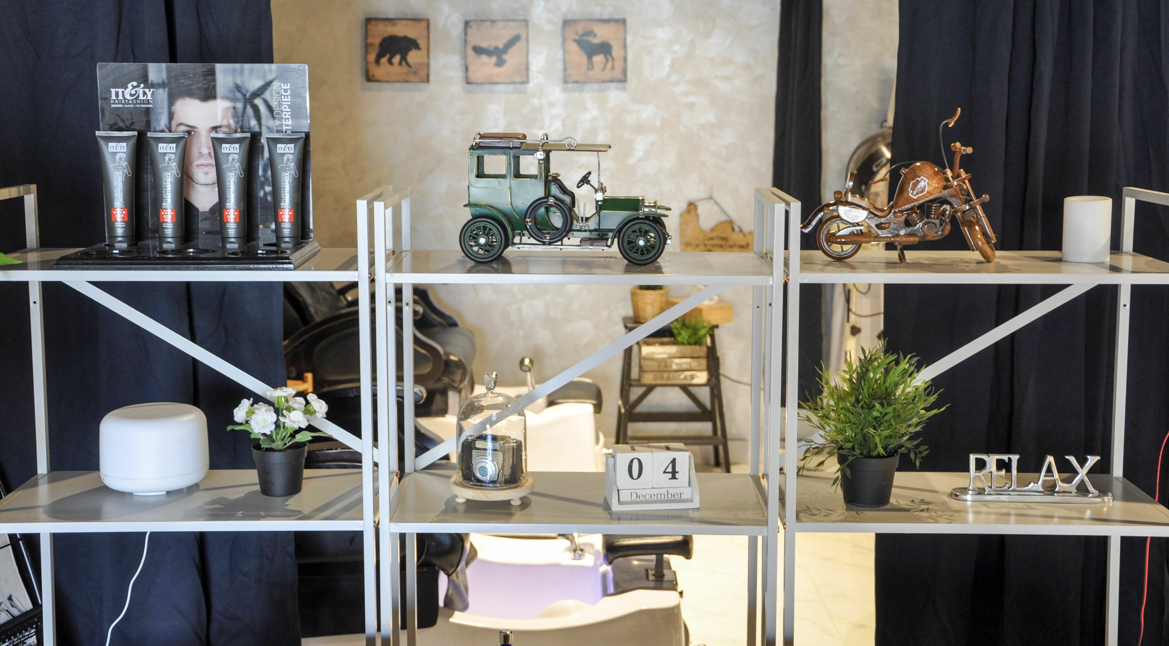 Stylish decor at The Loft Prime Gent's Salon, Dubai, Dubai, AE with vintage car model and grooming products.