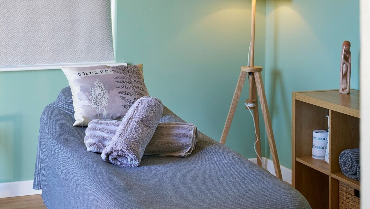 Cozy massage room at Thrive Therapies, Bideford, England, GB with soft lighting and towels.