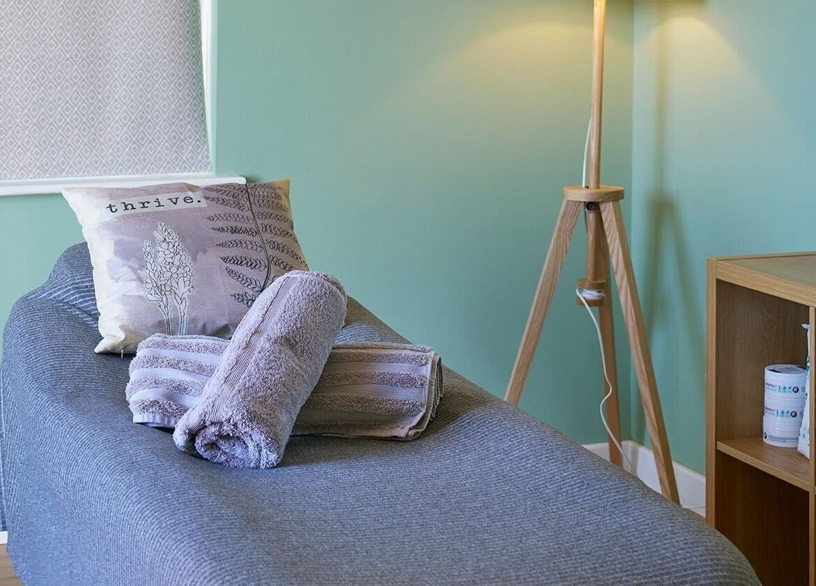 Cozy massage room at Thrive Therapies, Bideford, England, GB with soft lighting and towels.