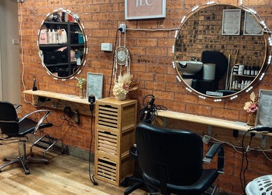 Warm salon interior at JLC Couture Artistry, Werrington, New South Wales, AU featuring stylish seating and mirrors.