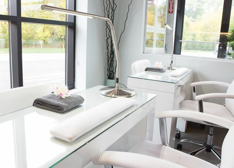 Elegant nail station at CedarHouse Spa in Mississauga, Ontario, CA, featuring sleek white chairs and a calming ambiance.