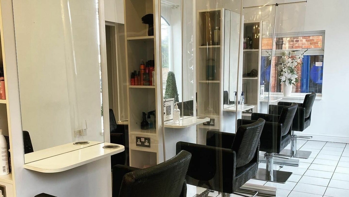 Modern salon interior at The Hair Company, Codsall, England, GB with sleek chairs and stylish decor.