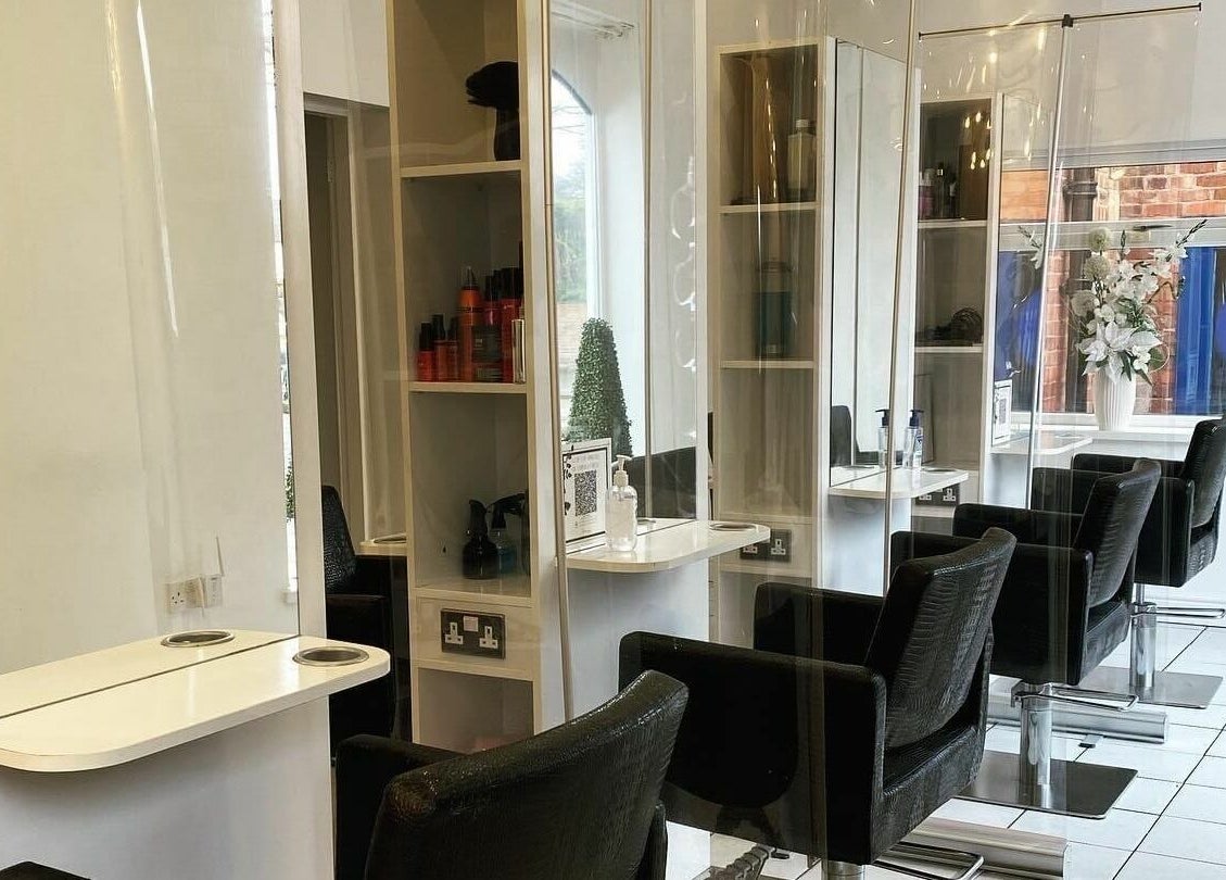 Modern salon interior at The Hair Company, Codsall, England, GB with sleek chairs and stylish decor.