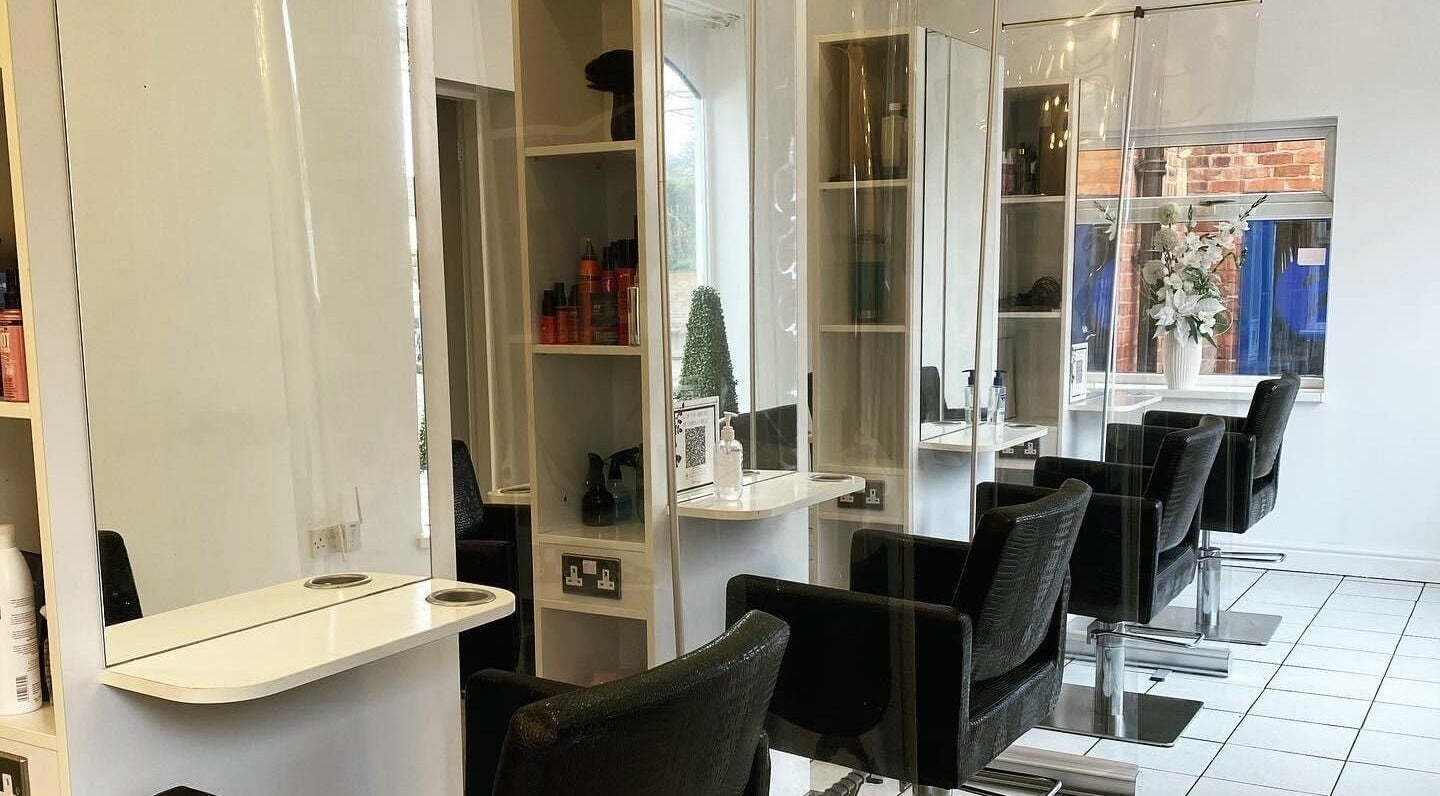 Modern salon interior at The Hair Company, Codsall, England, GB with sleek chairs and stylish decor.