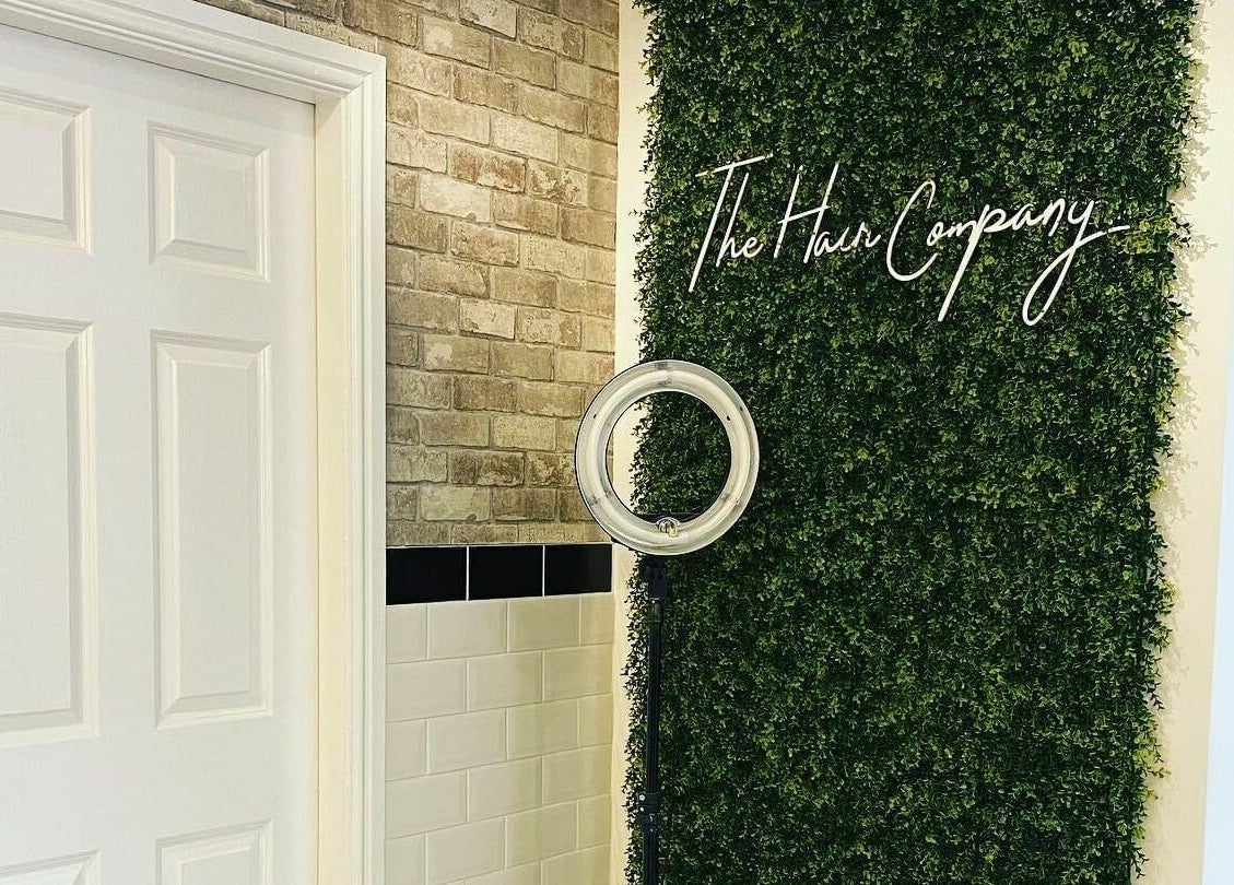 The Hair Company entrance with lush green wall in Codsall, England, GB.