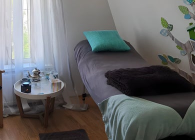 Een ontspannende massageruimte bij Lijf&Voet, Foxhol, Groningen, NL met zachte verlichting en comfortabele ligstoel.