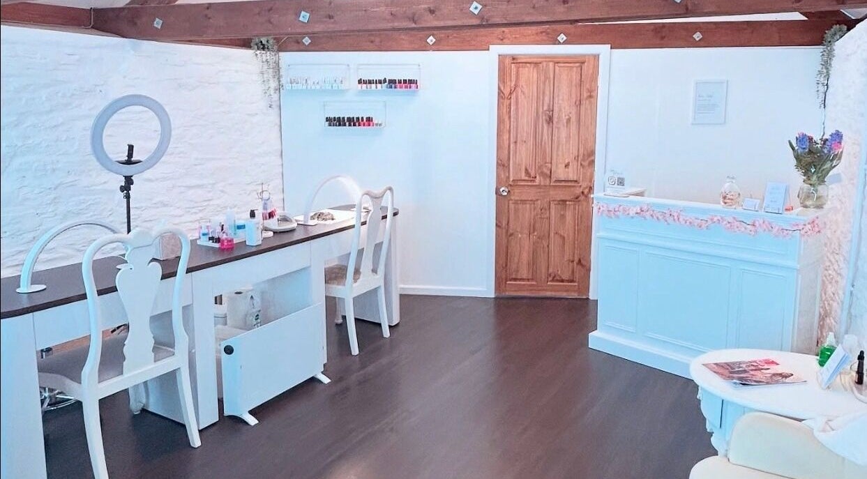 Bright and airy interior of Bliss Beauty, Truro, England, GB showcasing elegant furniture and nail polish collection.