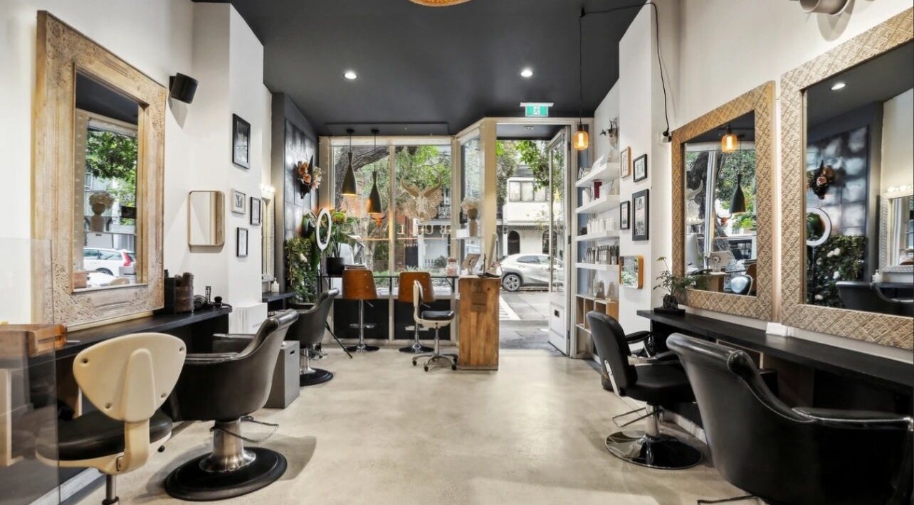 Spacious, stylish interior of Bull Hair Boutique in Redfern, NSW, AU, featuring elegant mirrors and seating.