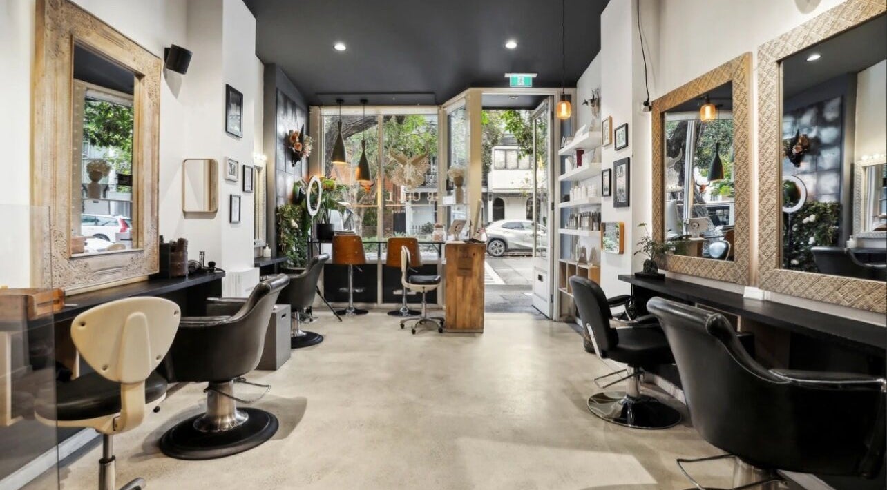 Modern interior of Bull Hair Boutique, Redfern, NSW, AU, showcasing sleek workstations with elegant mirrors.