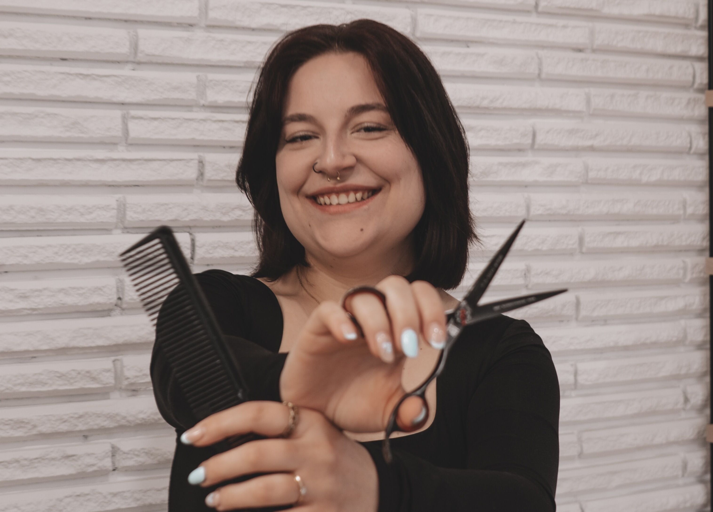 Coiffeuse souriante avec peigne et ciseaux à Concept beauté, Acton Vale, Québec, CA.