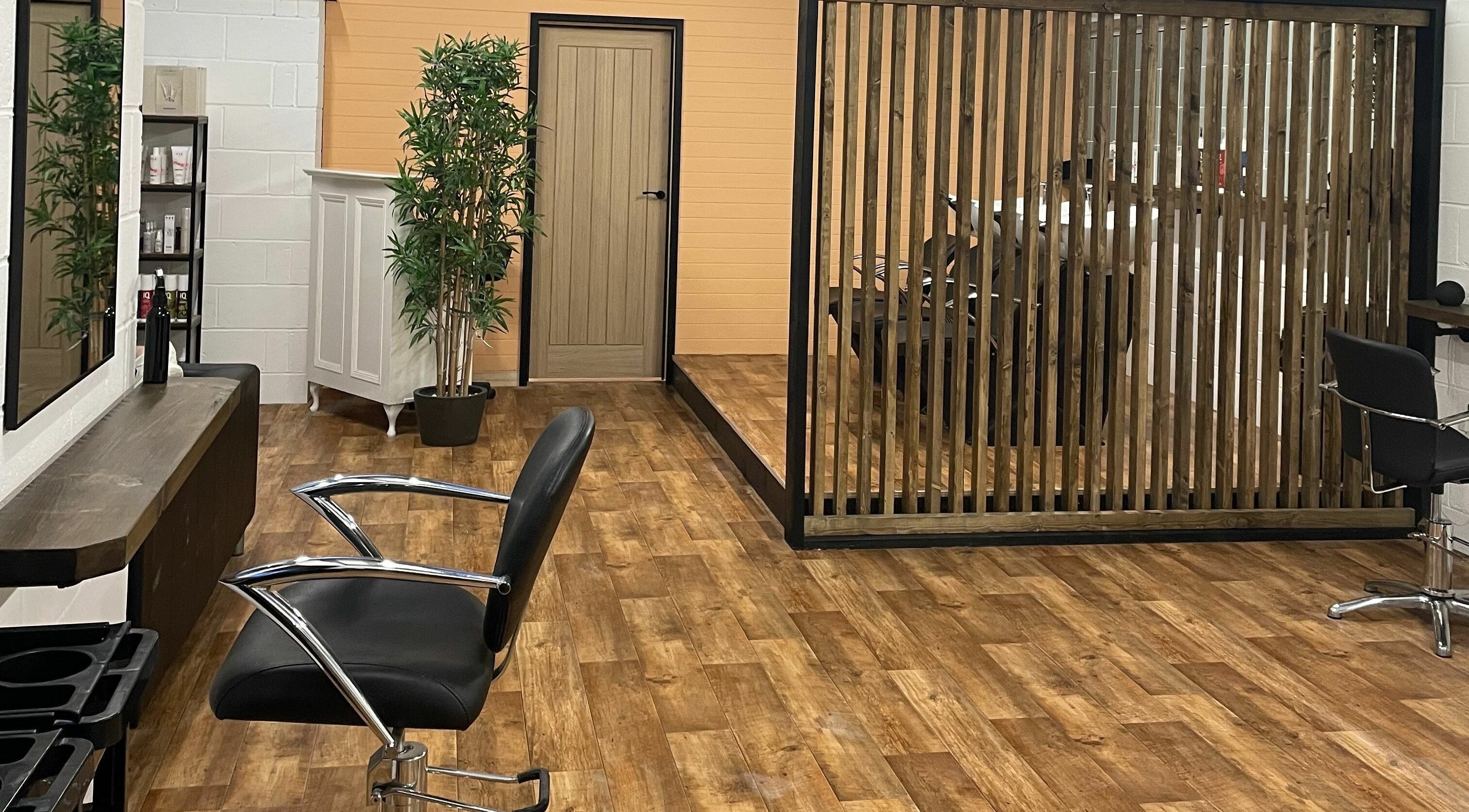 Elegant interior of Gadsby's Hair Salon in Luxulyan, England with sleek chairs and wood accents.