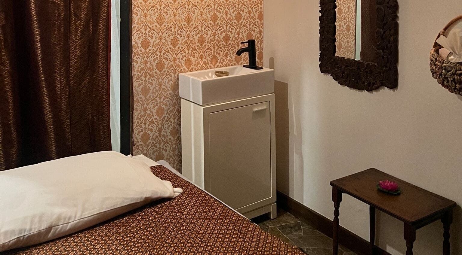 Serene massage room at Organic Thai Spa, Vancouver, British Columbia, CA featuring elegant decor and amenities.