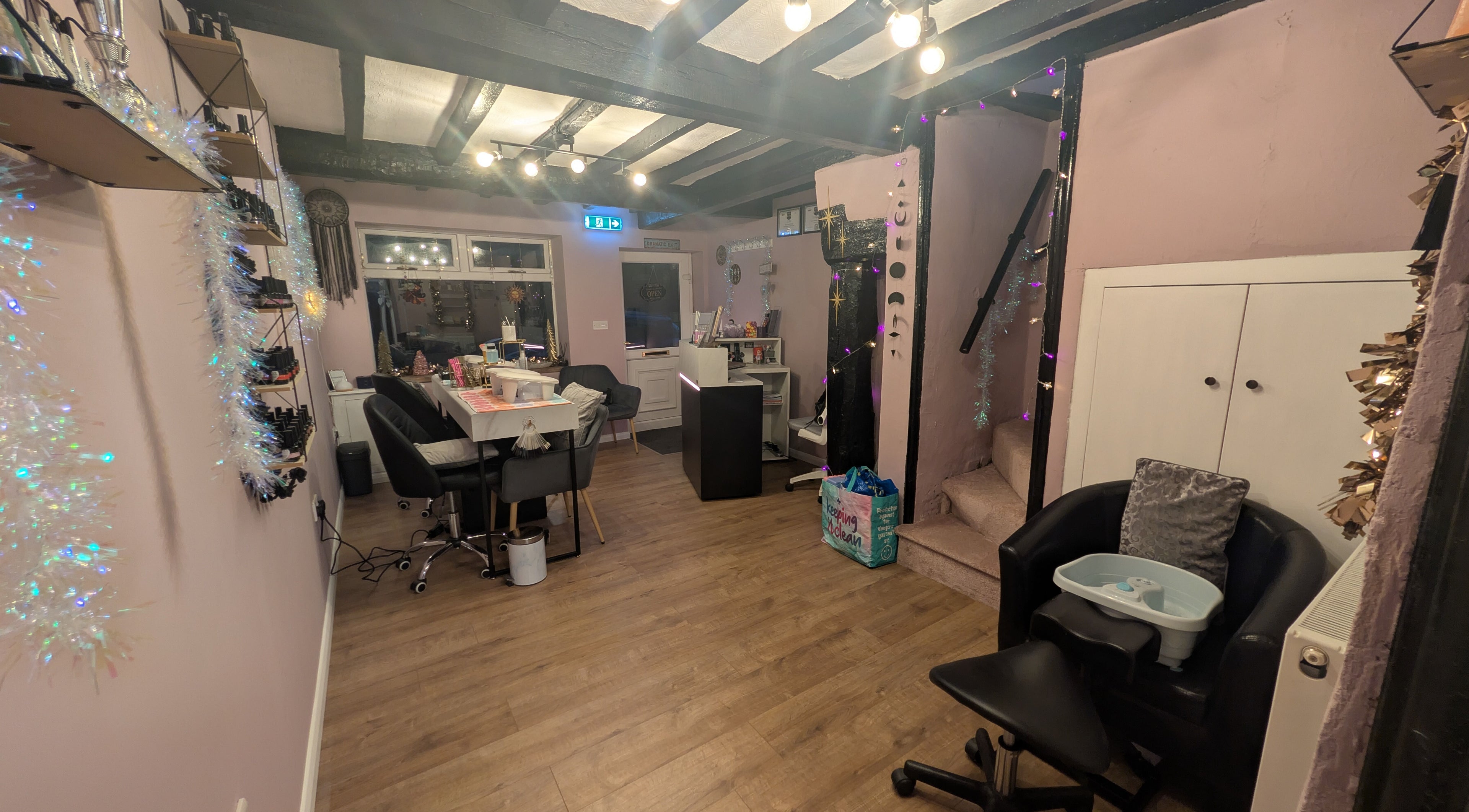 Cozy interior of Aura Alcove, a chic beauty salon in Stafford, England, GB with plush chairs and soft lighting.
