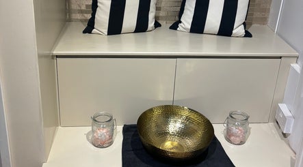 Tranquil foot spa setup at Beauty Within, Cheadle, England, GB with a brass basin and striped cushions.
