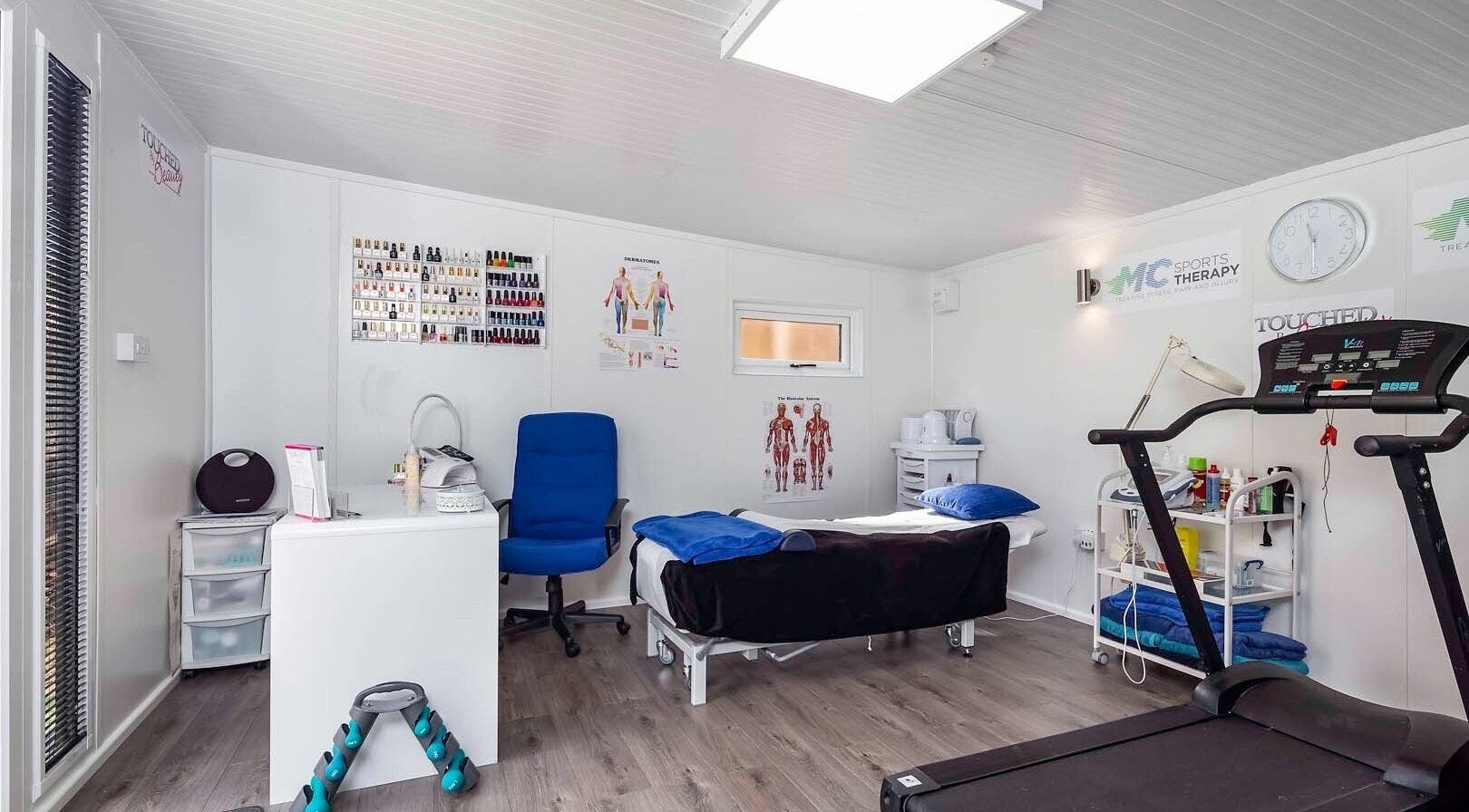 Relaxing therapy room at MC Sports Therapy, Stevenage, England, GB, featuring massage table and fitness equipment.