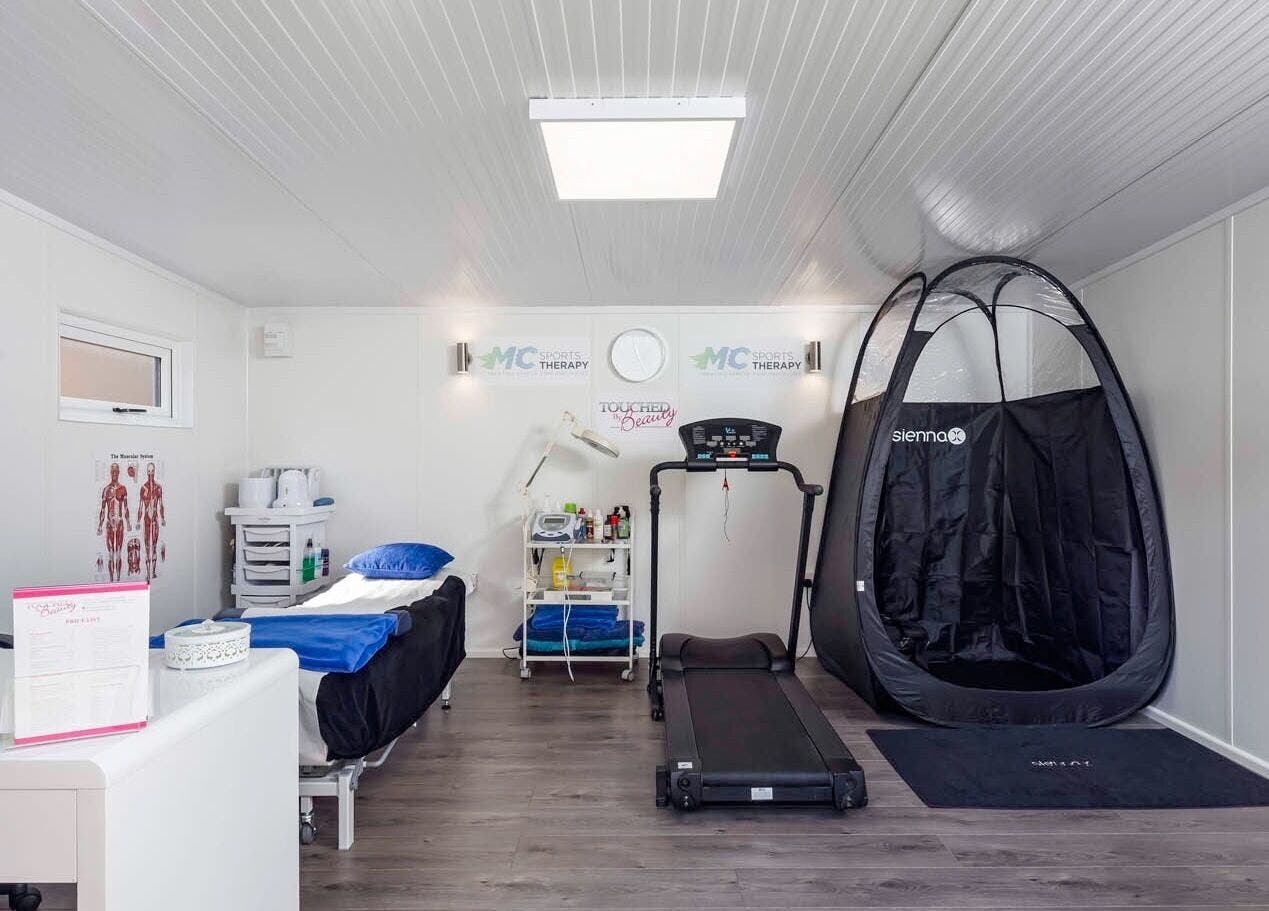 Modern therapy room at MC Sports Therapy, Stevenage, England, GB with treadmill and treatment bed.