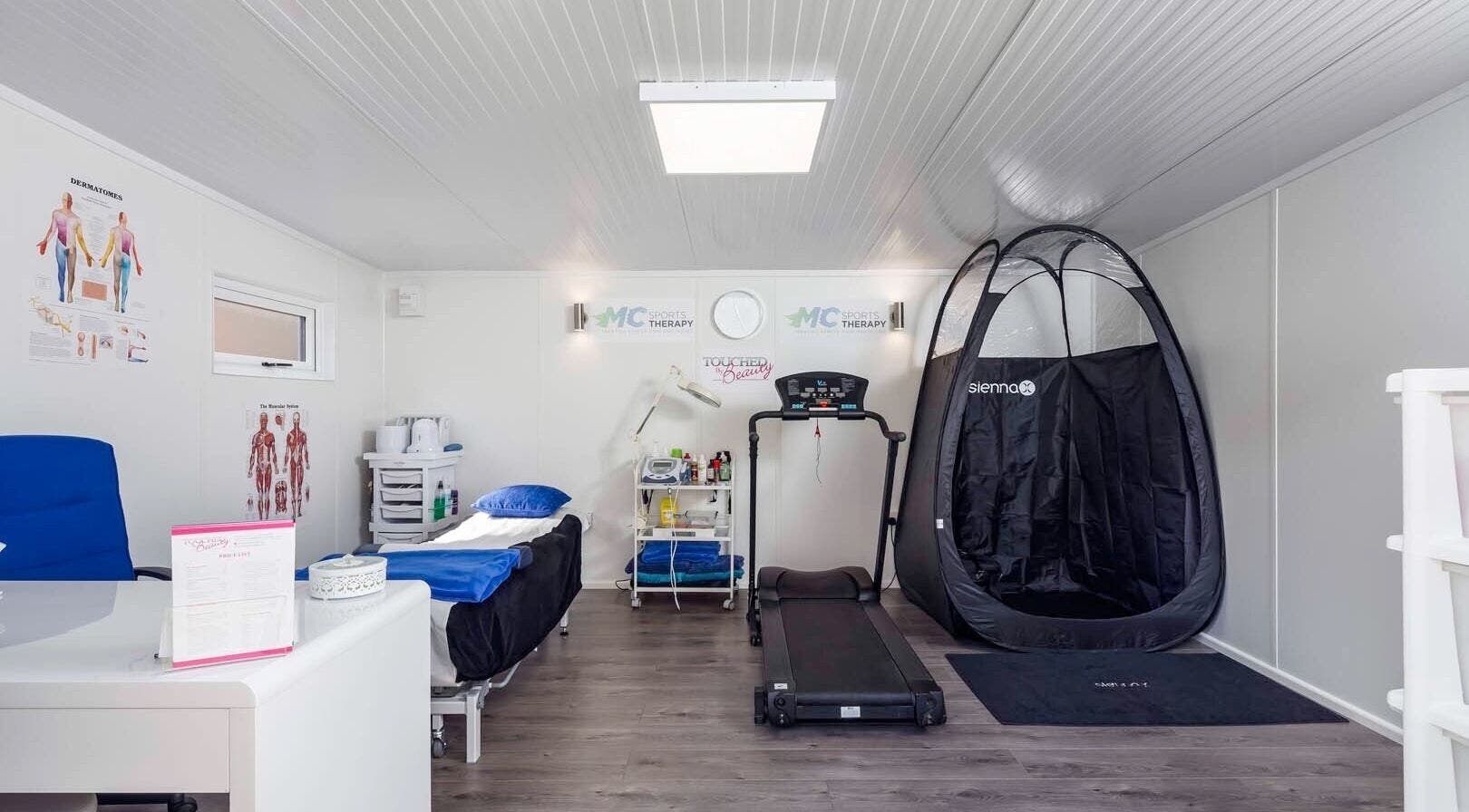 Modern therapy room at MC Sports Therapy, Stevenage, England, GB with treadmill and treatment bed.