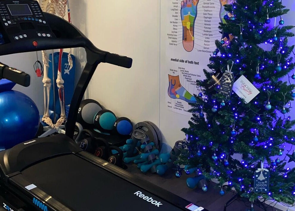 MC Sports Therapy in Stevenage, England features a treadmill and festive Christmas decorations.