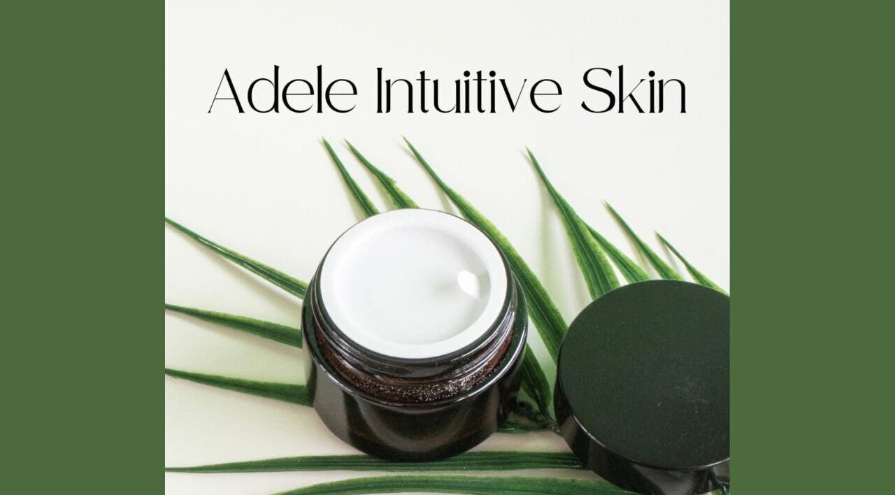 Adele Intuitive Skin Luton showcases a luxurious cream jar on lush green leaves.