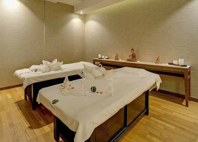 Relaxing massage room at Reborn Spa Ramee Rose Slimming Wellness Center, Manama, BH, with serene ambiance.