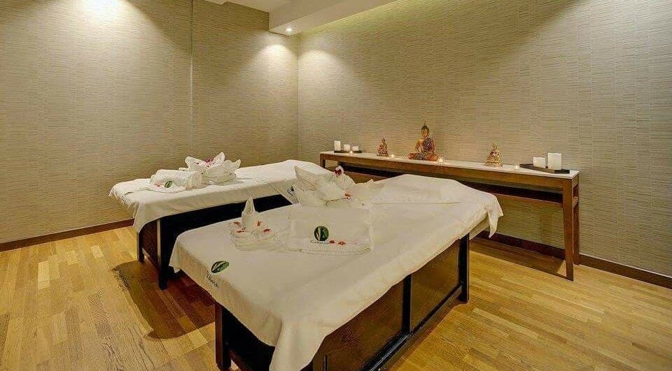 Relaxing massage room at Reborn Spa Ramee Rose Slimming Wellness Center, Manama, BH, with serene ambiance.