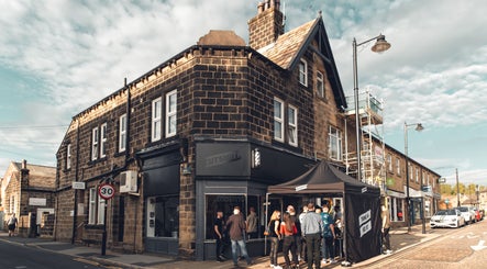 Cutsmith venue in Yeadon, England, GB, showcasing a bustling street corner with patrons.