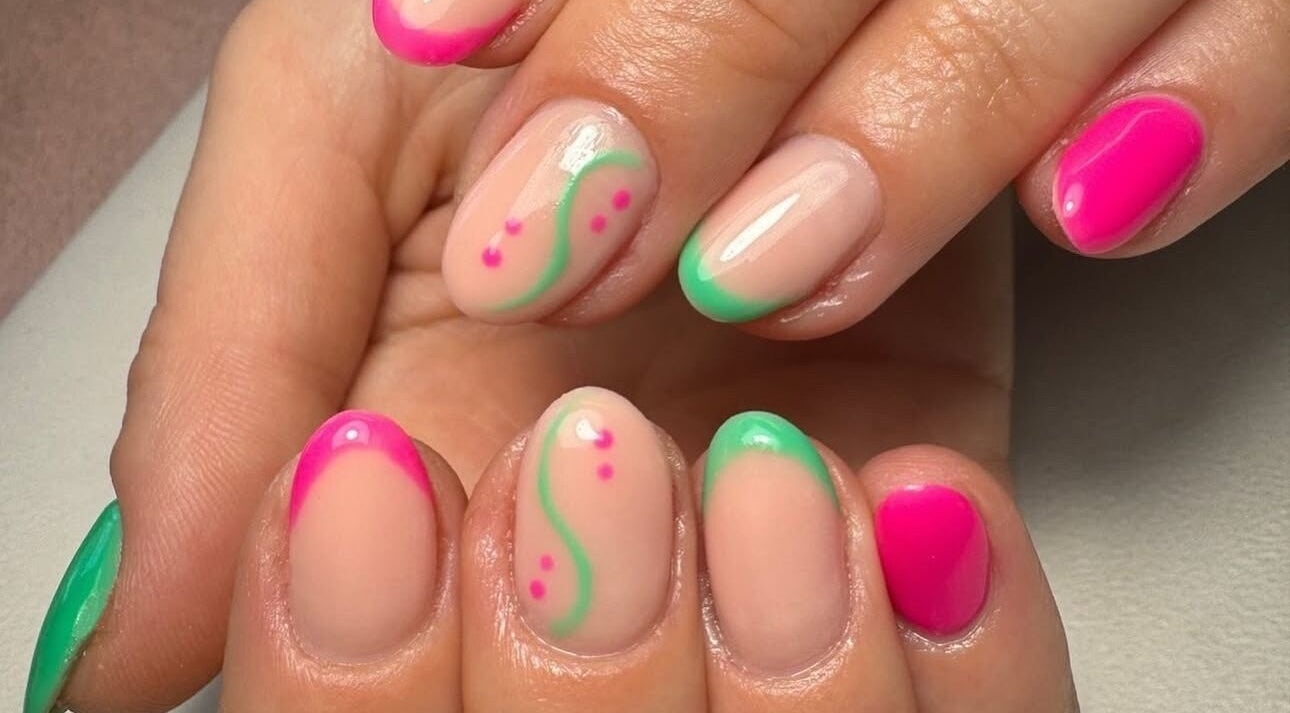 Stylish nail art with neon pink and green tips at True Nails, Glasgow, Scotland, GB.