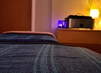 Calming massage room at Laura Leongomez, Neyland, Wales, GB, with soft lighting and serene decor.