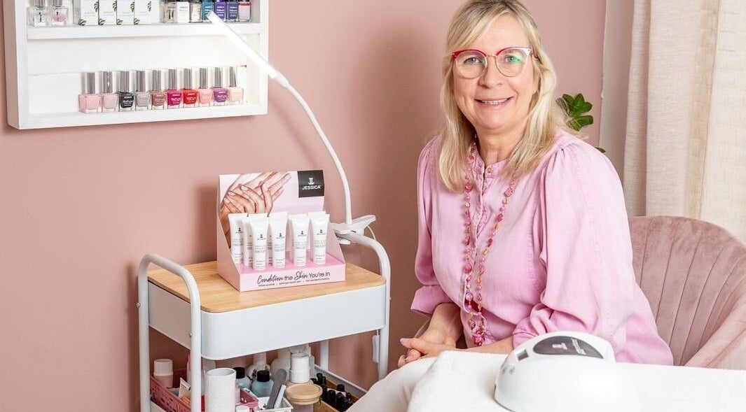 Smiling beauty expert at The Beauty Specialist, Clarkson, Western Australia, AU, surrounded by products.