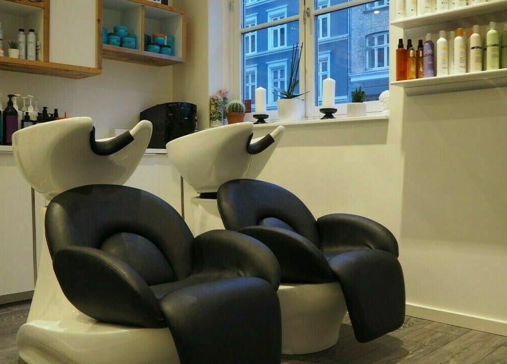 Moderne vaskestation hos Salon De Choix i København, Denmark, DK med luksuriøse stole og produkter på hylderne.