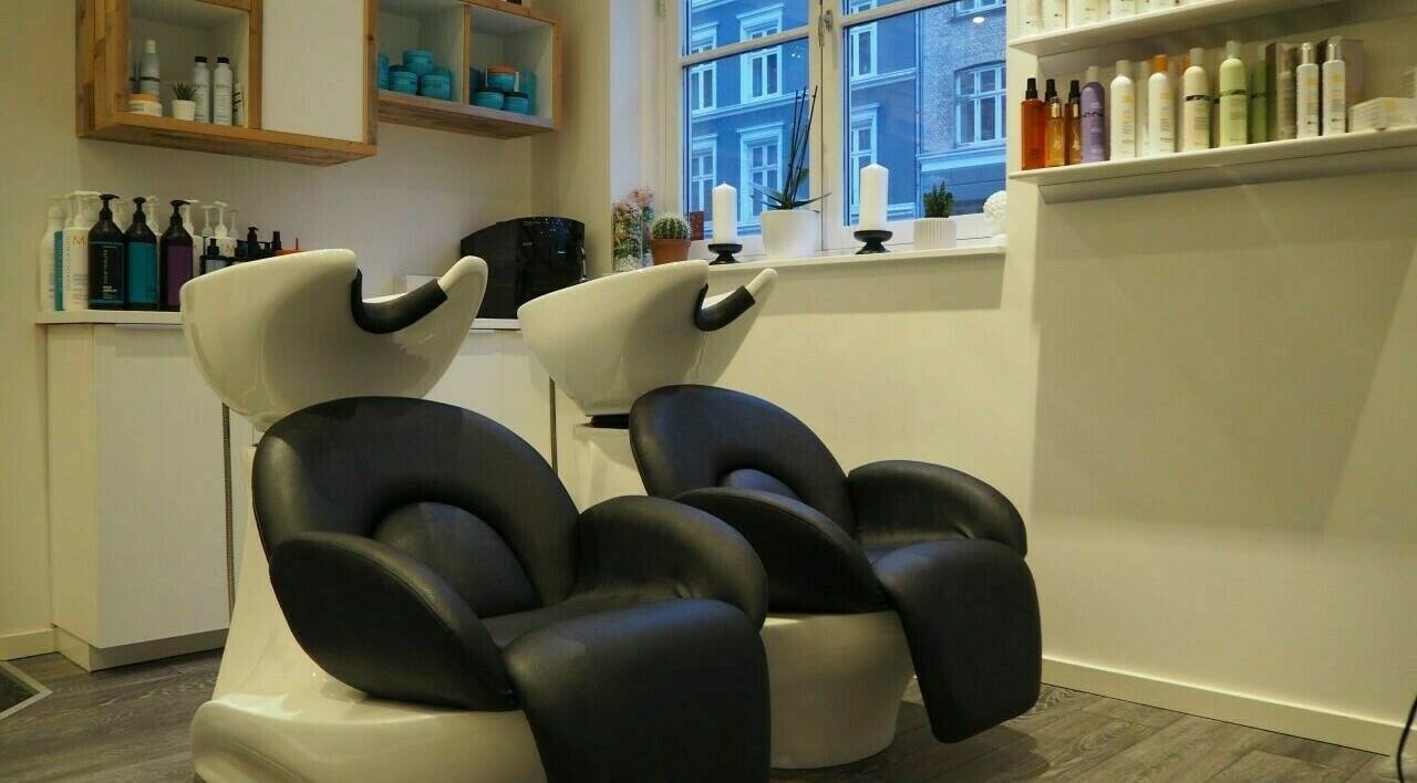 Moderne vaskestation hos Salon De Choix i København, Denmark, DK med luksuriøse stole og produkter på hylderne.