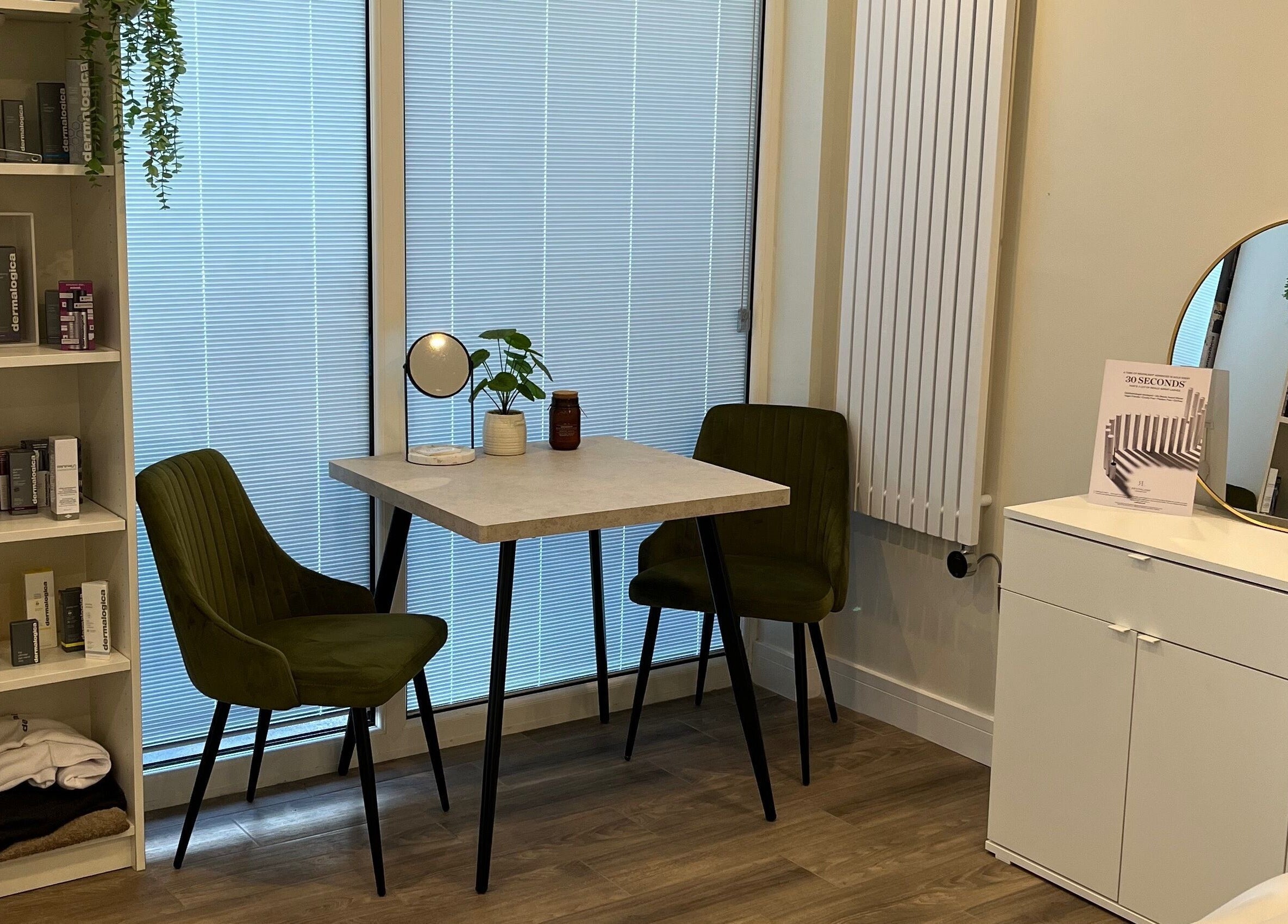 A cozy consultation area at Ls Aesthetics, Miskin, Wales, GB with chairs, a table, and beauty products.