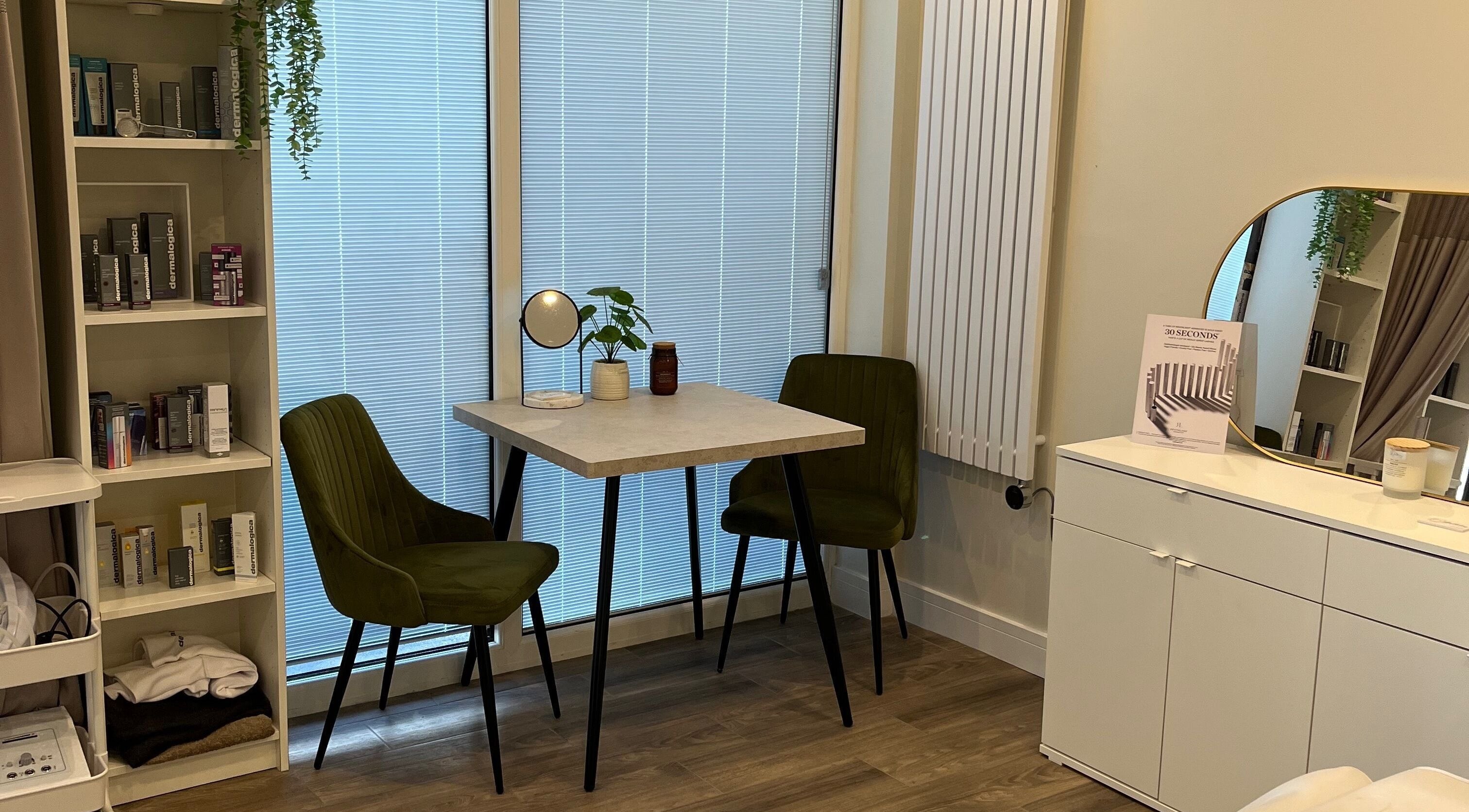 A cozy consultation area at Ls Aesthetics, Miskin, Wales, GB with chairs, a table, and beauty products.