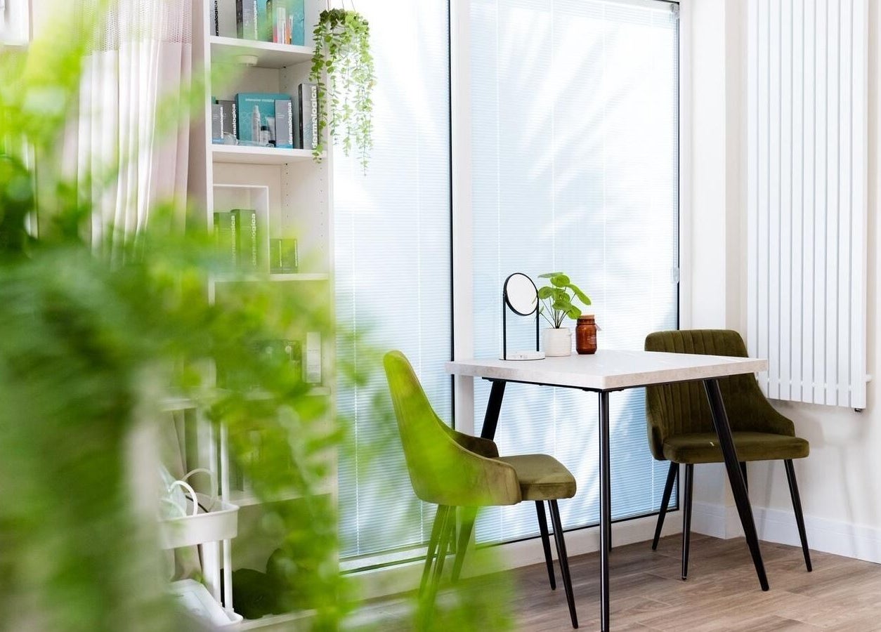Inviting seating area at Ls Aesthetics, Miskin, Wales, GB with plants and shelves, offering a calming atmosphere.