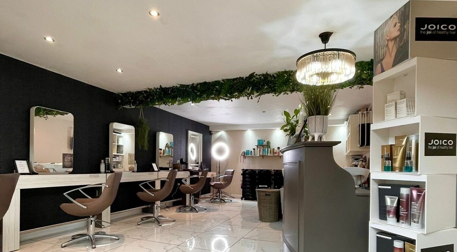Modern interior of Lox Avenue, Tonypandy, Wales, GB showcasing elegant salon chairs and product displays.