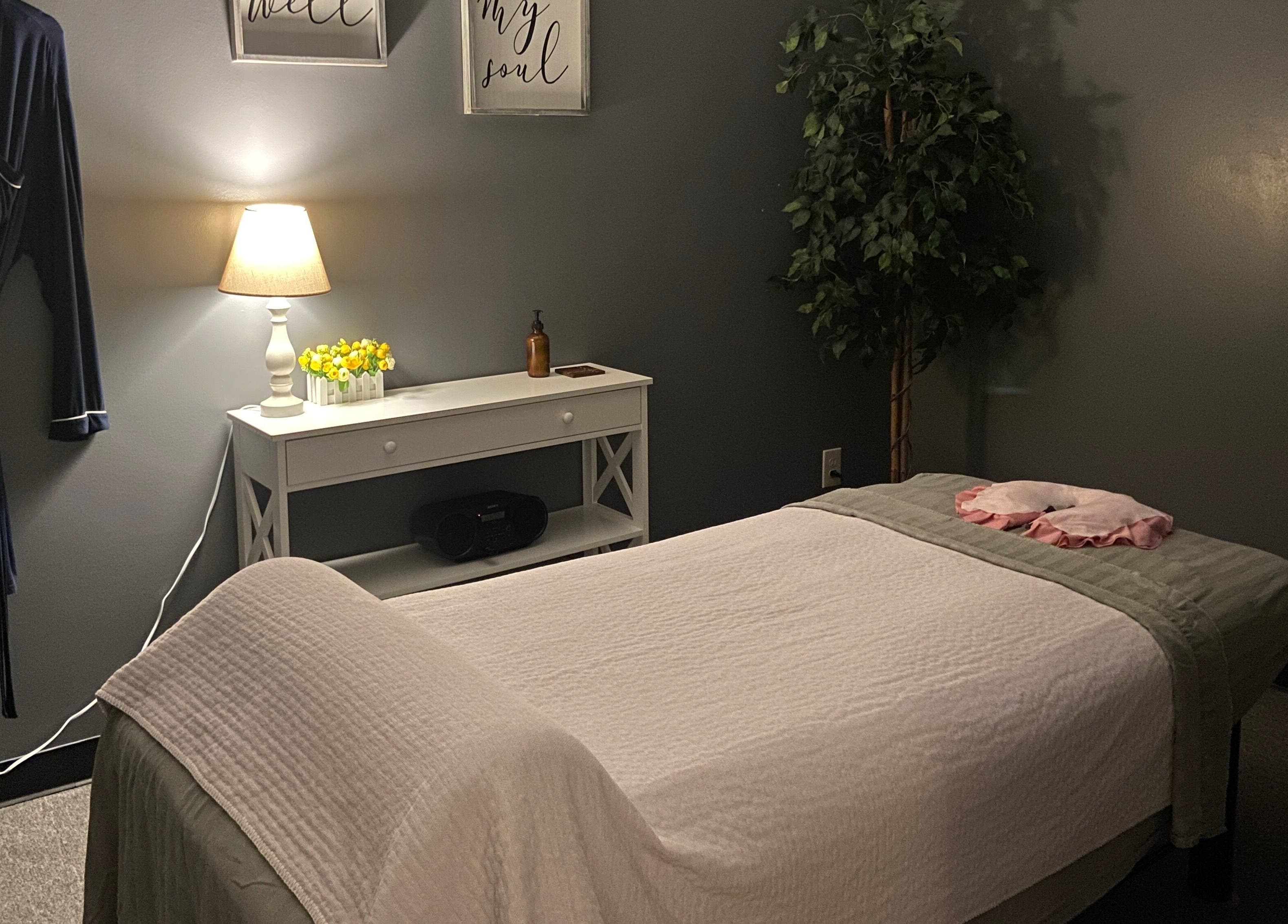 Relaxing massage room at Zhenni Spa in Murfreesboro, Tennessee, featuring cozy lighting and soothing decor.