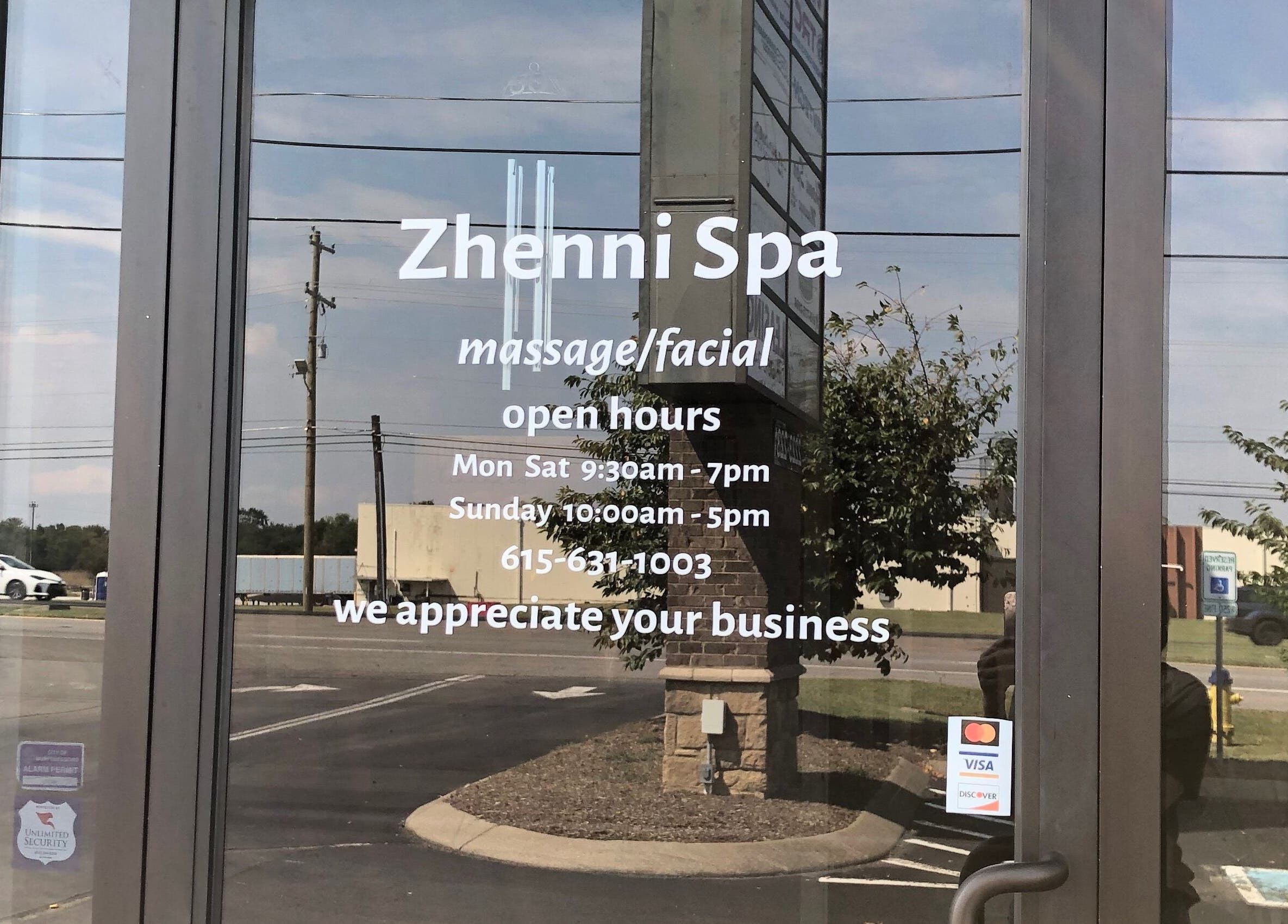 Entrance door of Zhenni Spa in Murfreesboro, Tennessee, US, displaying hours and contact details.