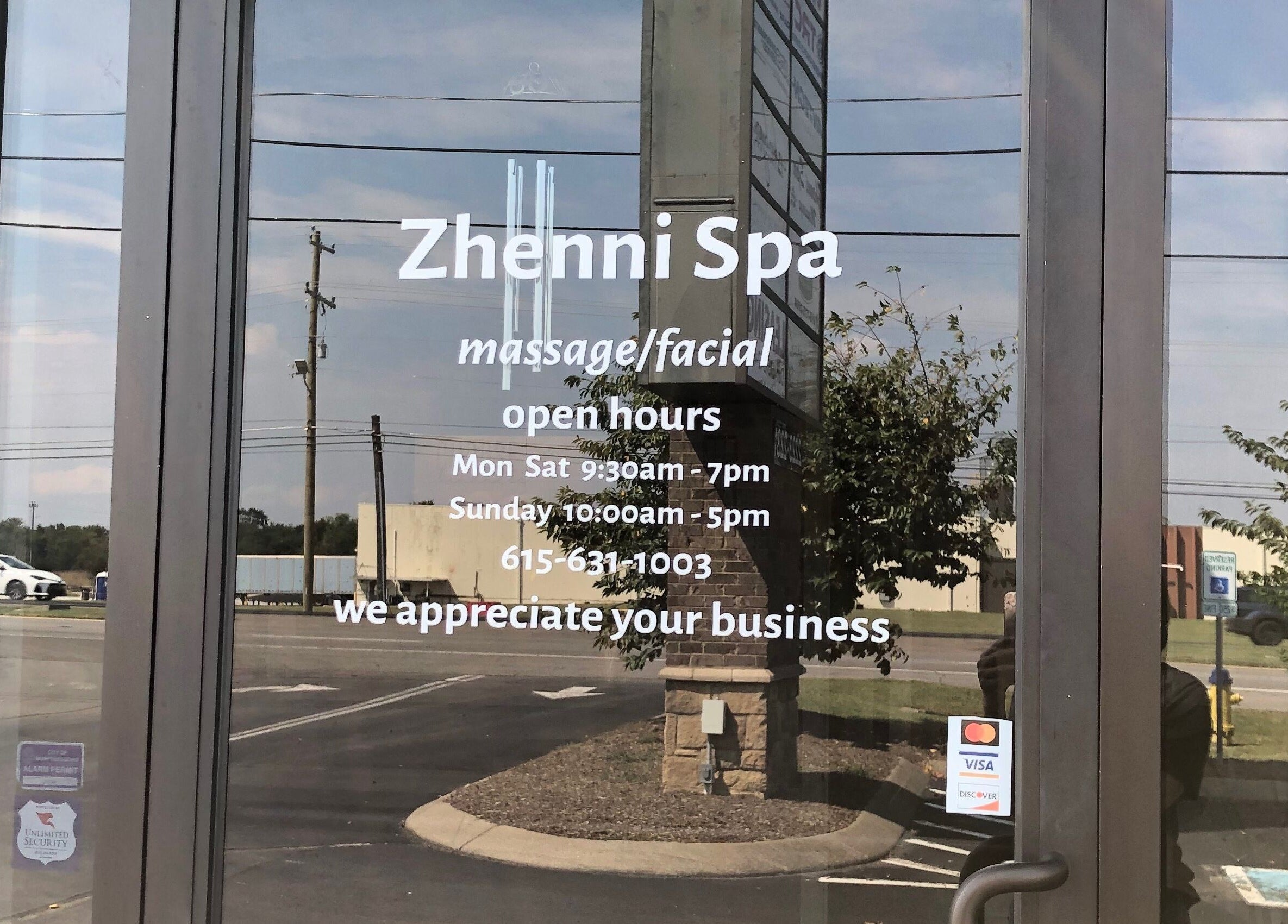 Entrance door of Zhenni Spa in Murfreesboro, Tennessee, US, displaying hours and contact details.