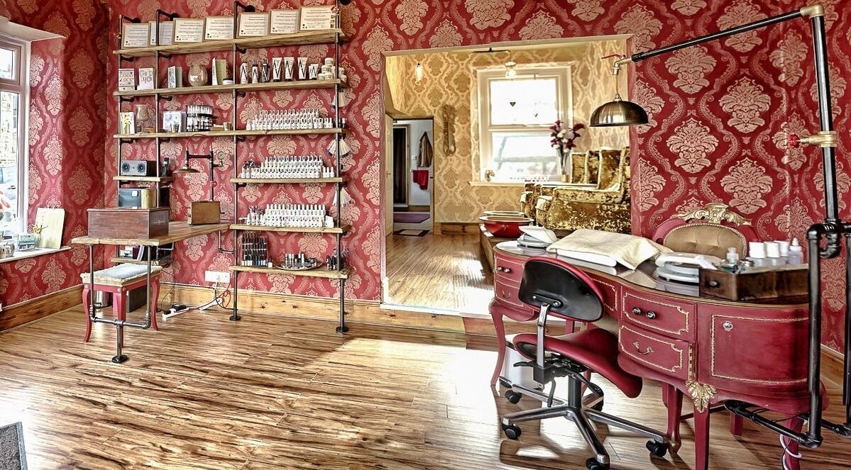 Luxurious red and gold interior of Gilded Dreams spa in Carnforth, England, GB showcasing elegant beauty salon decor.